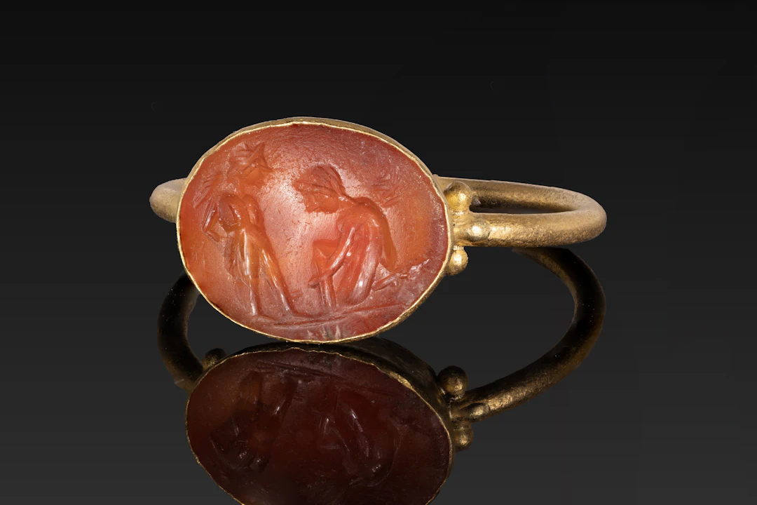 LATE ROMAN GOLD RING WITH CARNELIAN INTAGLIO OF EROTES