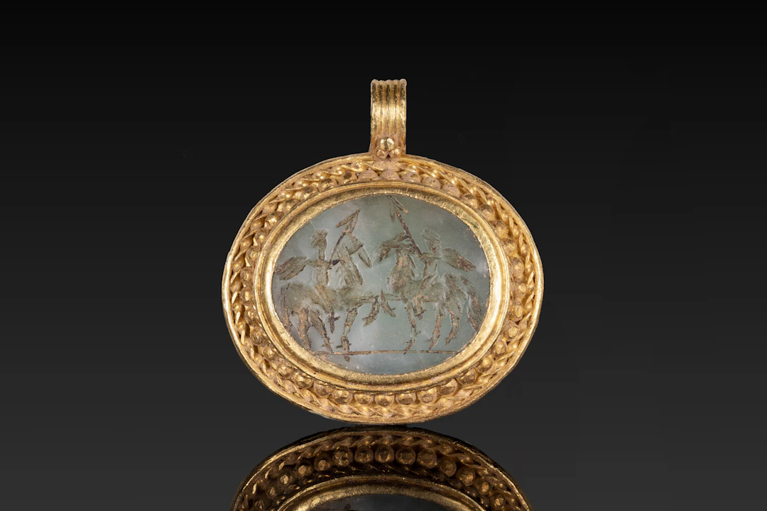 ROMAN GOLD AND MALACHITE PENDANT DEPICTING EROTES RIDING HORSES AND