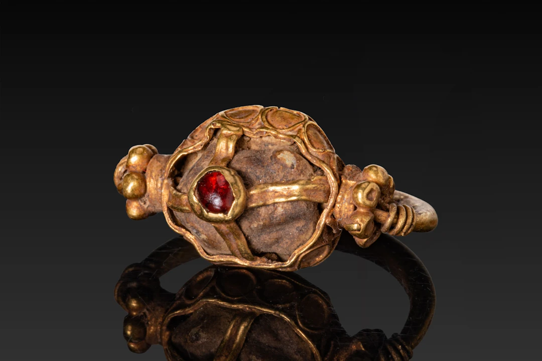 BYZANTINE OPENWORK HIGH KARAT GOLD DOMED RING WITH CENTRAL RED GARNET CABOCHON