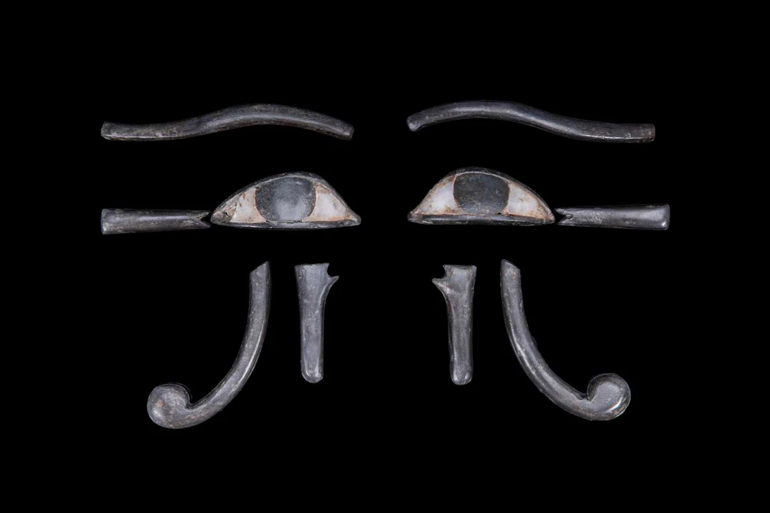 EGYPTIAN PAIR OF COMPOSITE STONE UDJAT-EYE INLAYS