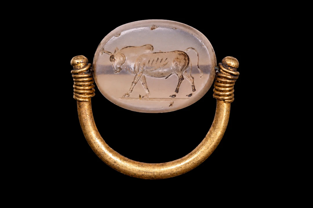 EASTERN GREEK GOLD SWIVEL RING WITH CHALCEDONY SCARAB ENGRAVED WITH A BULL