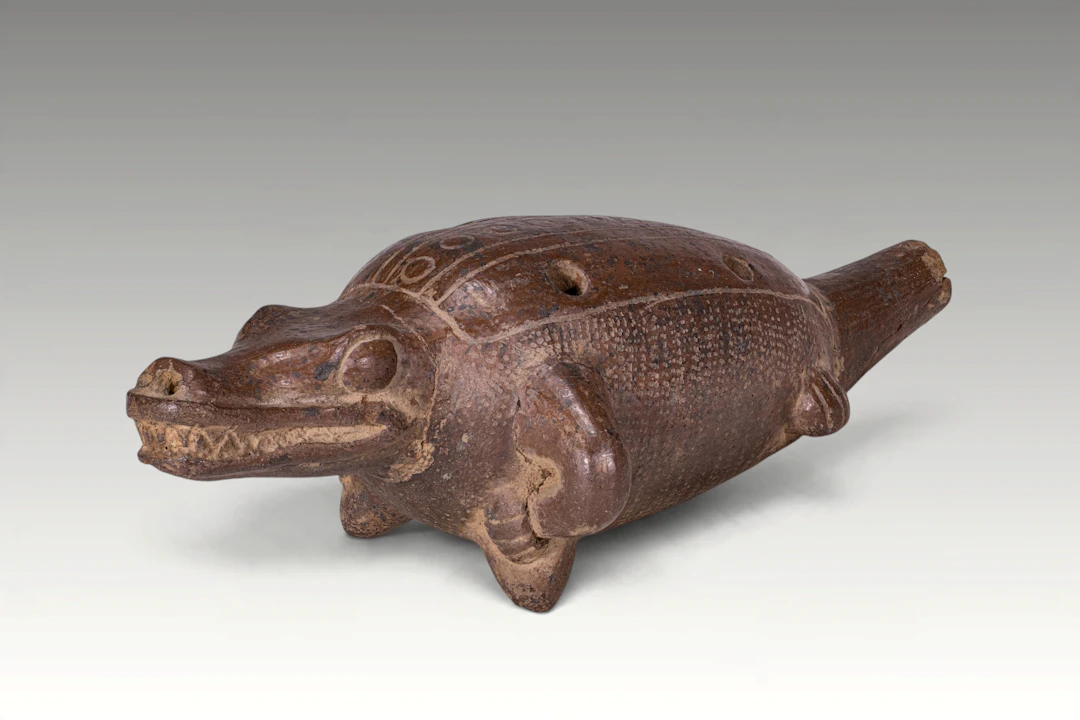 PRE-COLUMBIAN ZOOMORPHIC POTTERY WHISTLE IN THE FORM OF A CROCODILE