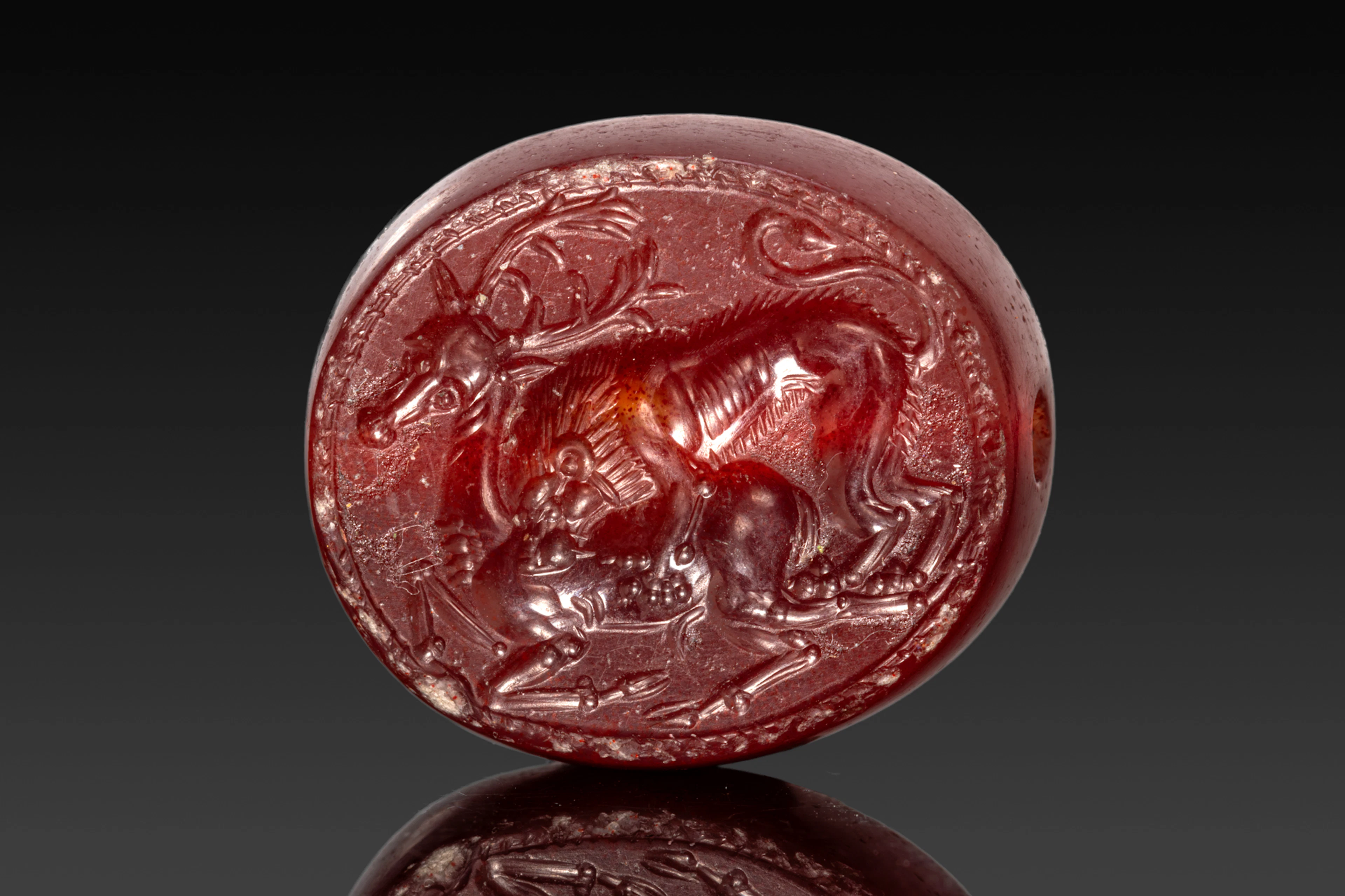 ETRUSCAN CARNELIAN STAMP SEAL WITH A LION ATTACKING A STAG