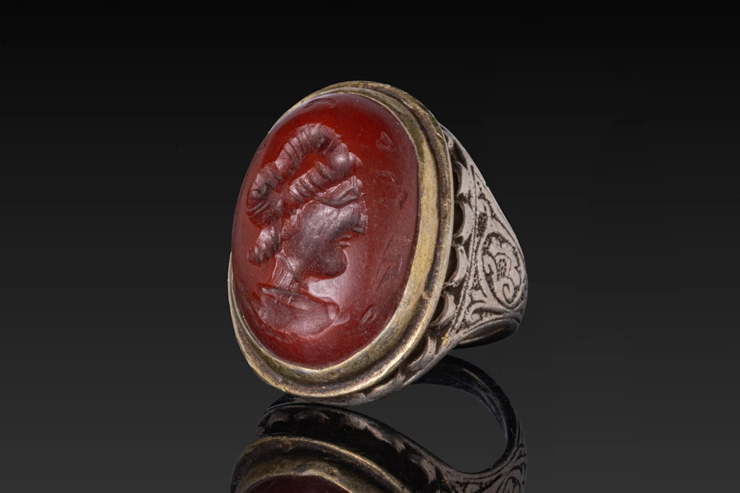 OTTOMAN OR QAJAR SILVER-GILT RING WITH RED STONE INTAGLIO PORTRAIT