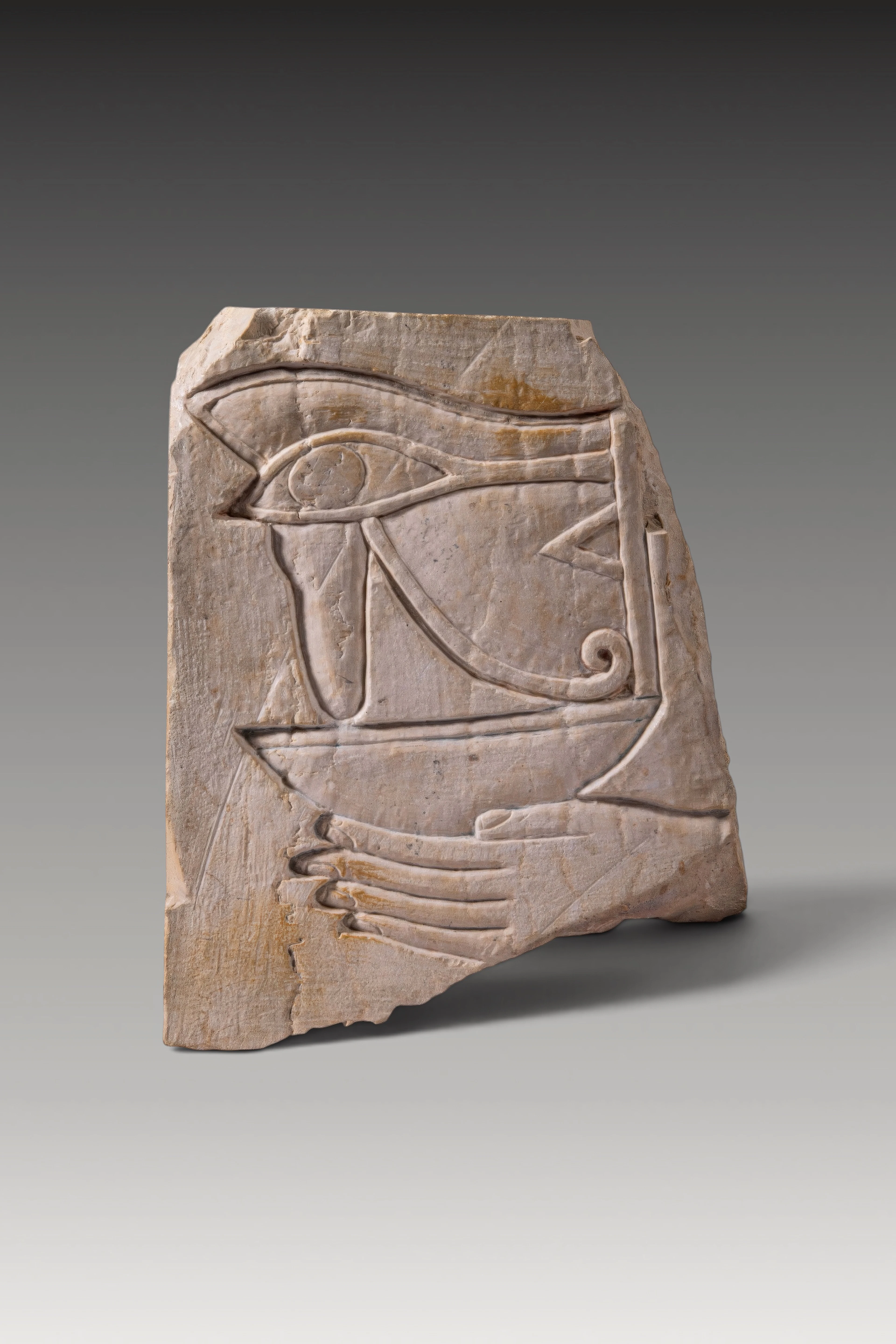 EGYPTIAN LIMESTONE RELIEF FRAGMENT WITH A LARGE UDJAT-EYE SUPPORTED