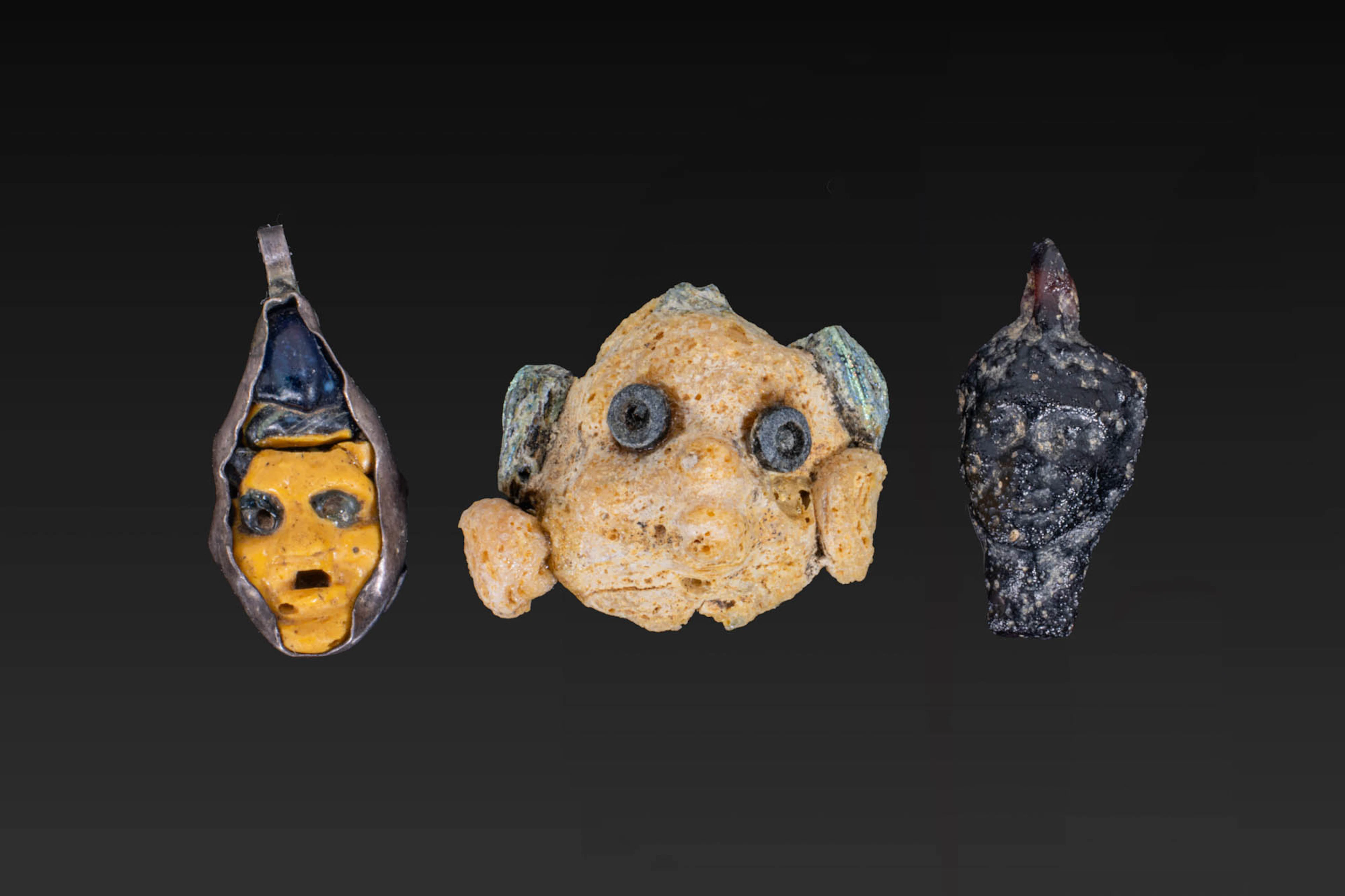 COLLECTION OF PHOENICIAN AND ROMAN GLASS FACE PENDANTS