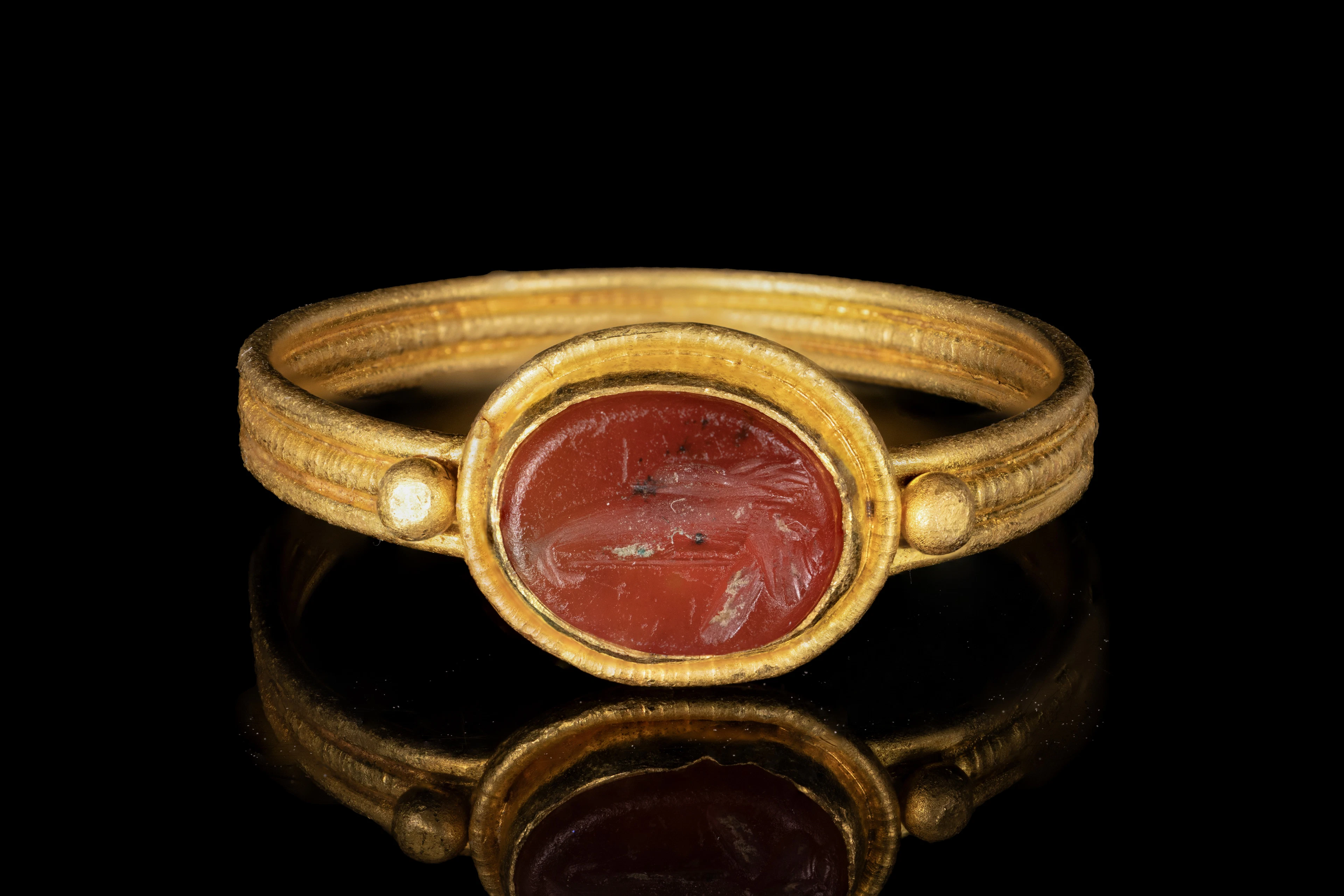 LATE ROMAN GOLD RING WITH CARNELIAN INTAGLIO OF A LEGIONARY EAGLE'S HEAD