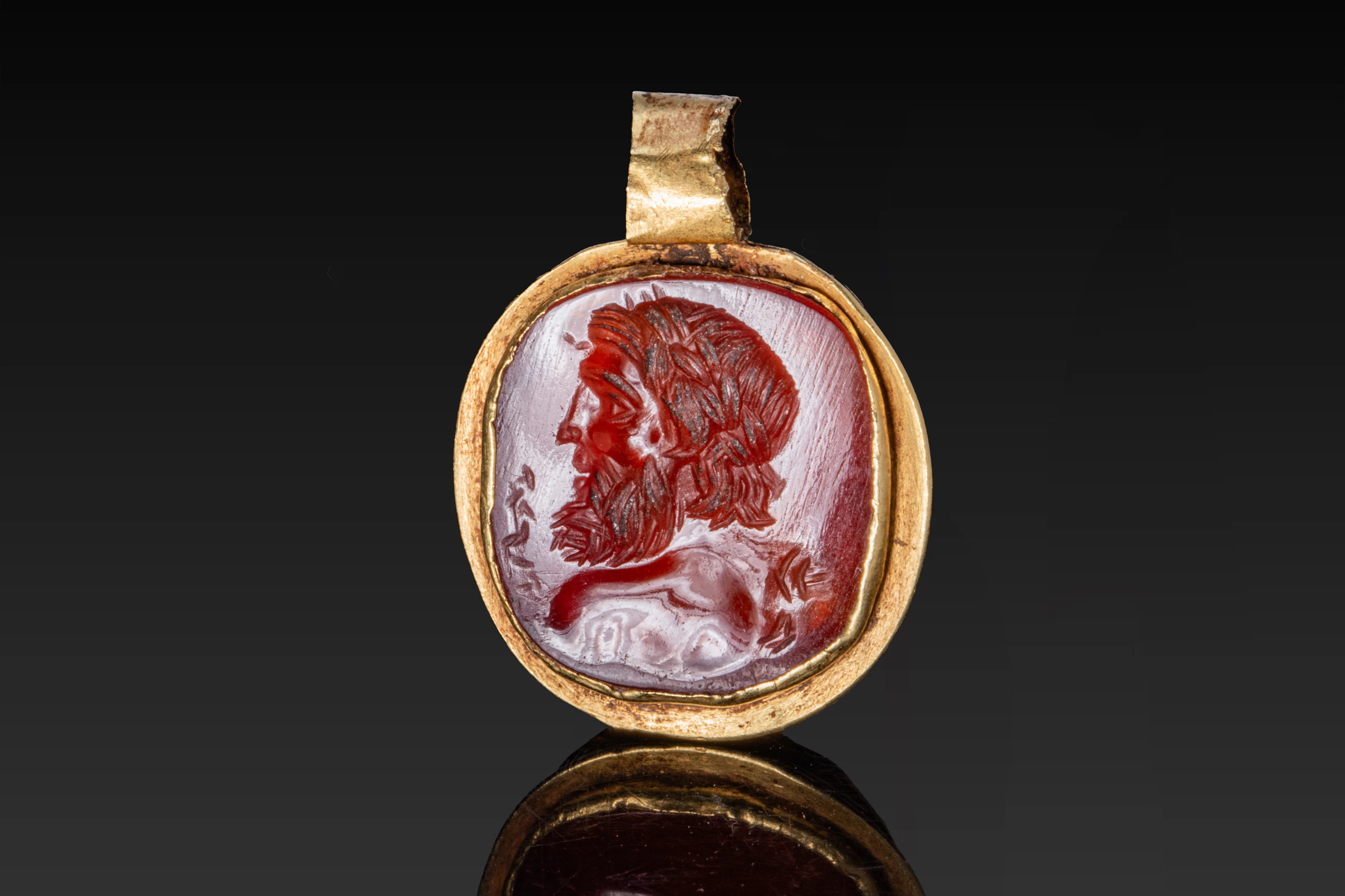 ROMAN GOLD PENDANT WITH CARNELIAN INTAGLIO OF A BUST OF JUPITER