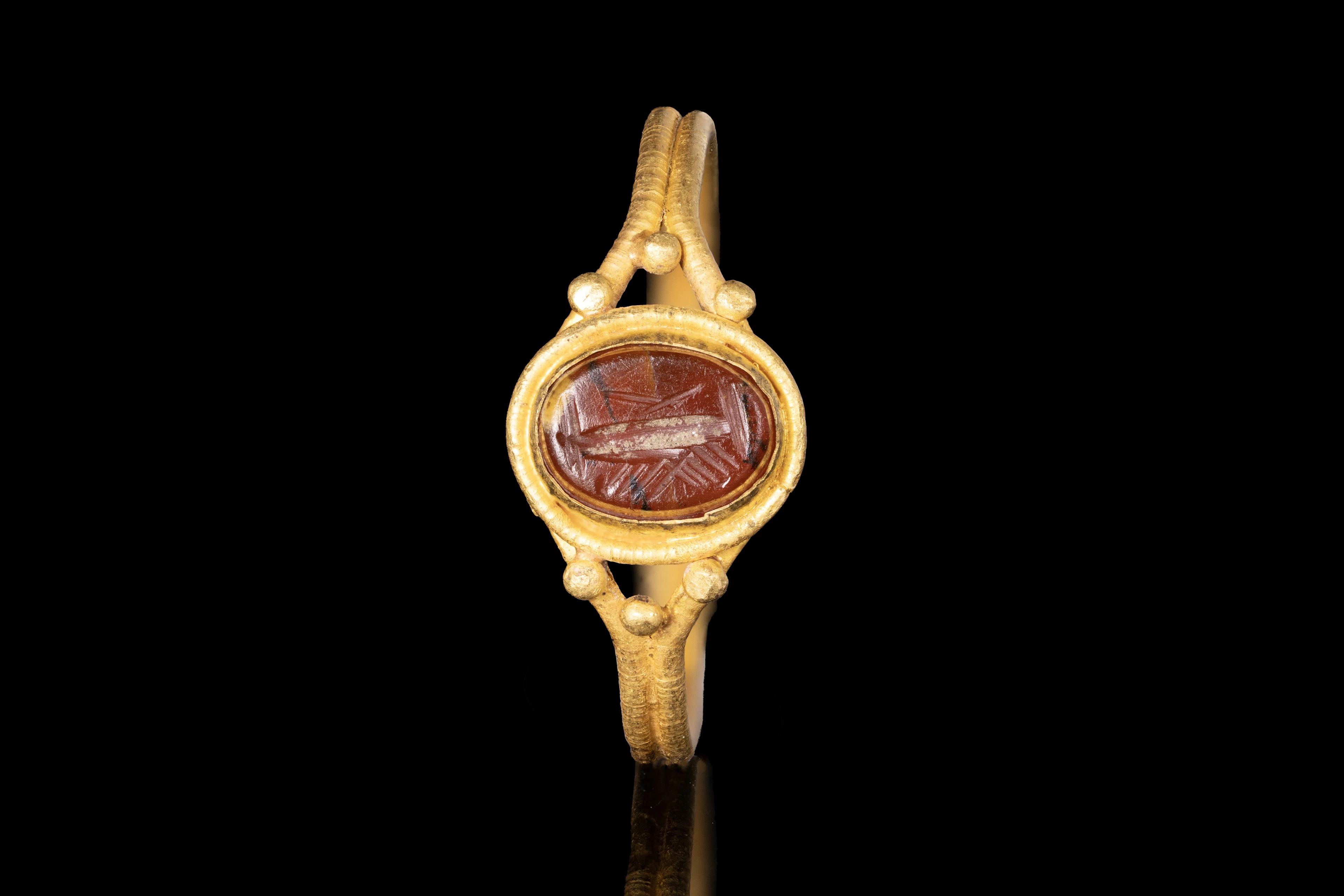 LATE ROMAN GOLD RING WITH GARNET INTAGLIO OF CLASPED HANDS