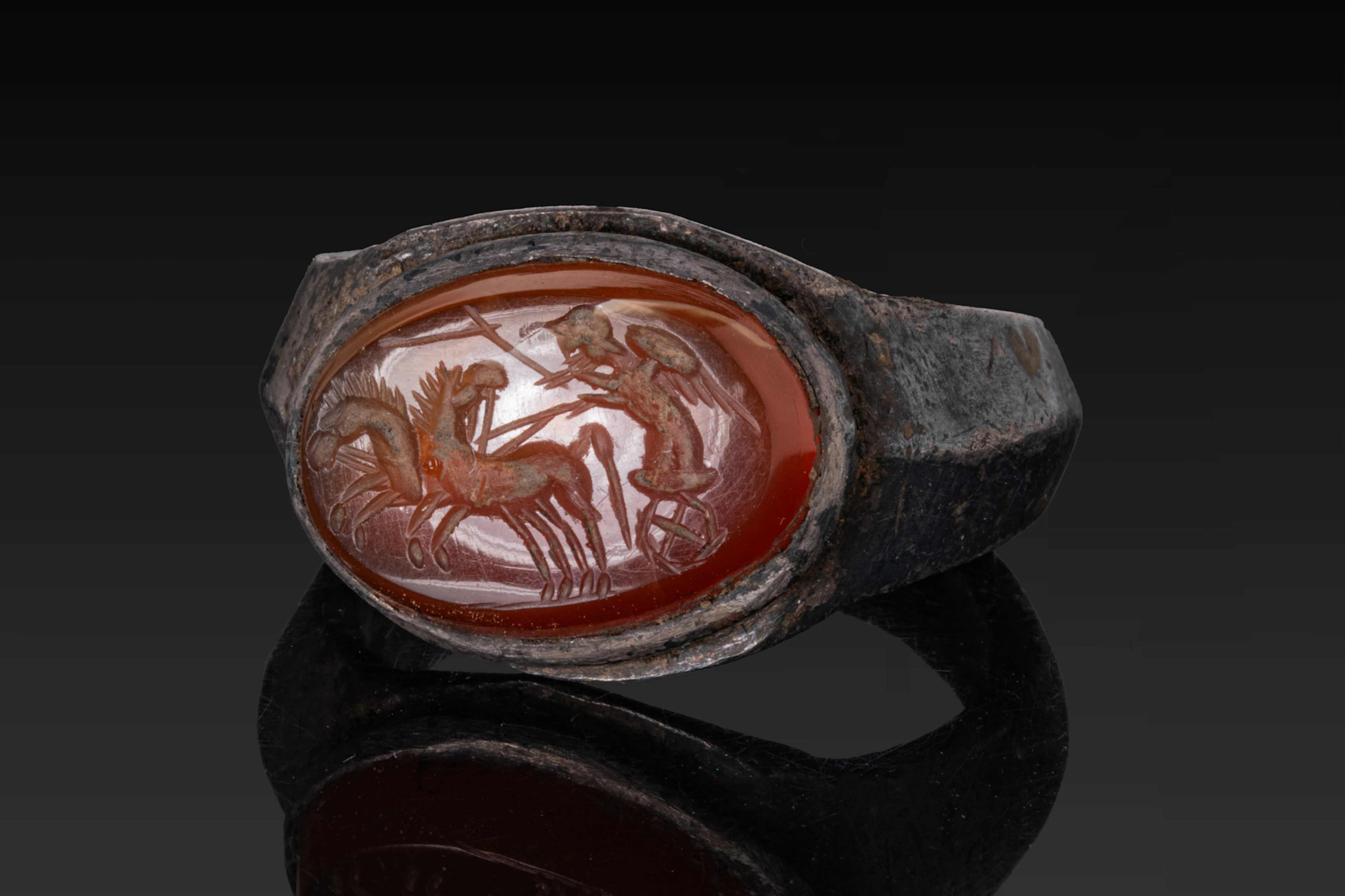 ROMAN SILVER RING WITH CARNELIAN INTAGLIO OF CUPID DRIVING A BIGA