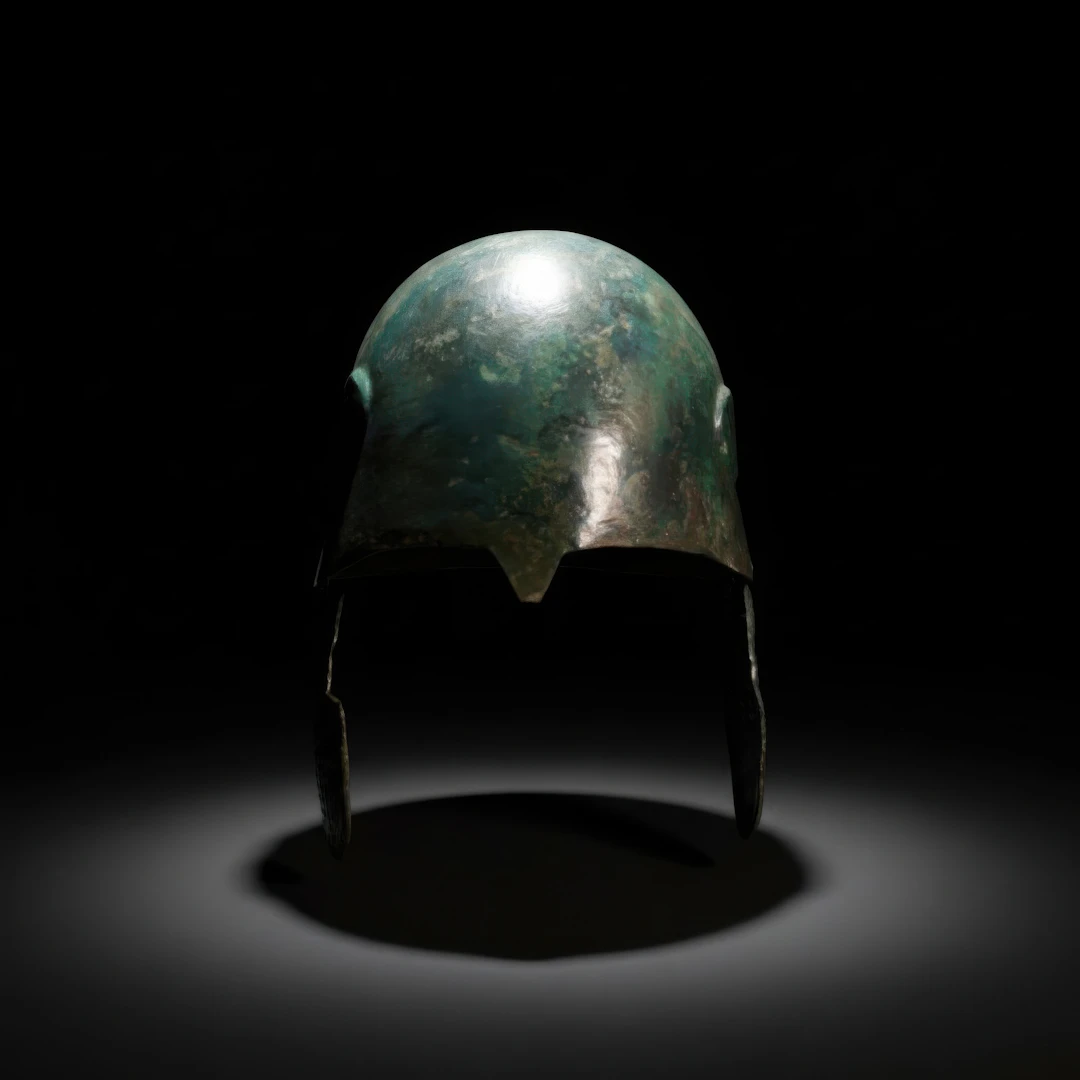 RARE EARLY CHALCIDIAN BRONZE HELMET WITH DECORATED CHEEKPIECES