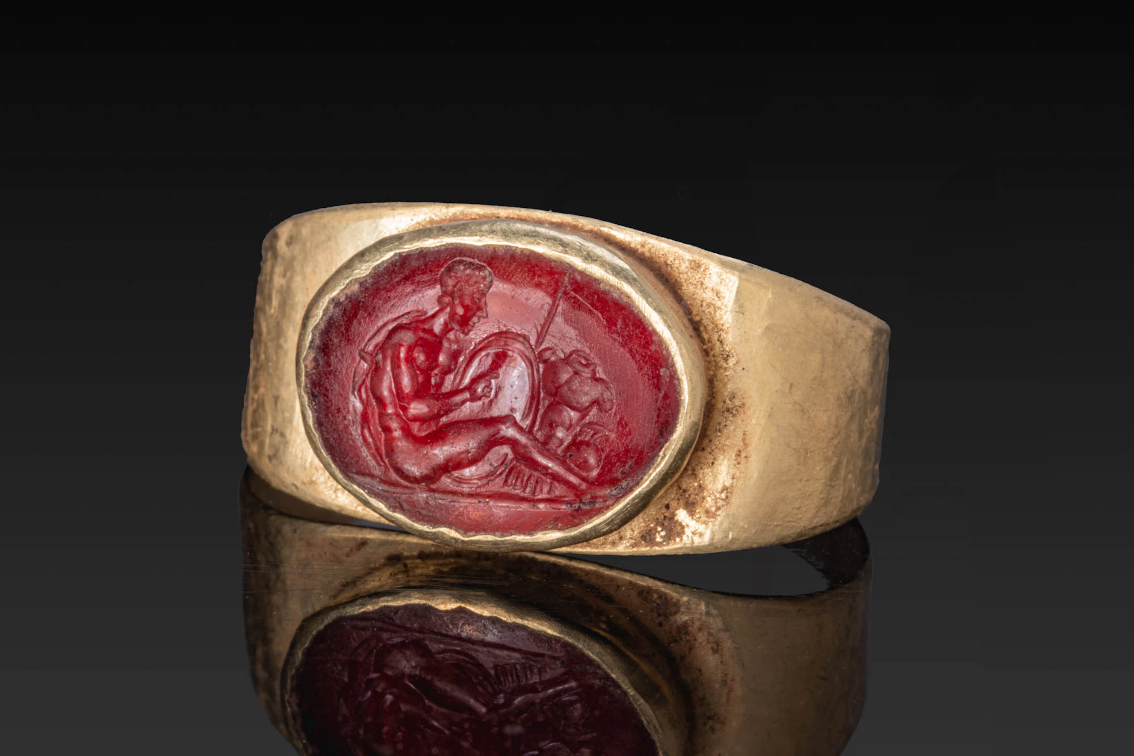 ROMAN GARNET INTAGLIO OF SEATED MARS WITH TROPHIES OF WAR IN GOLD RING