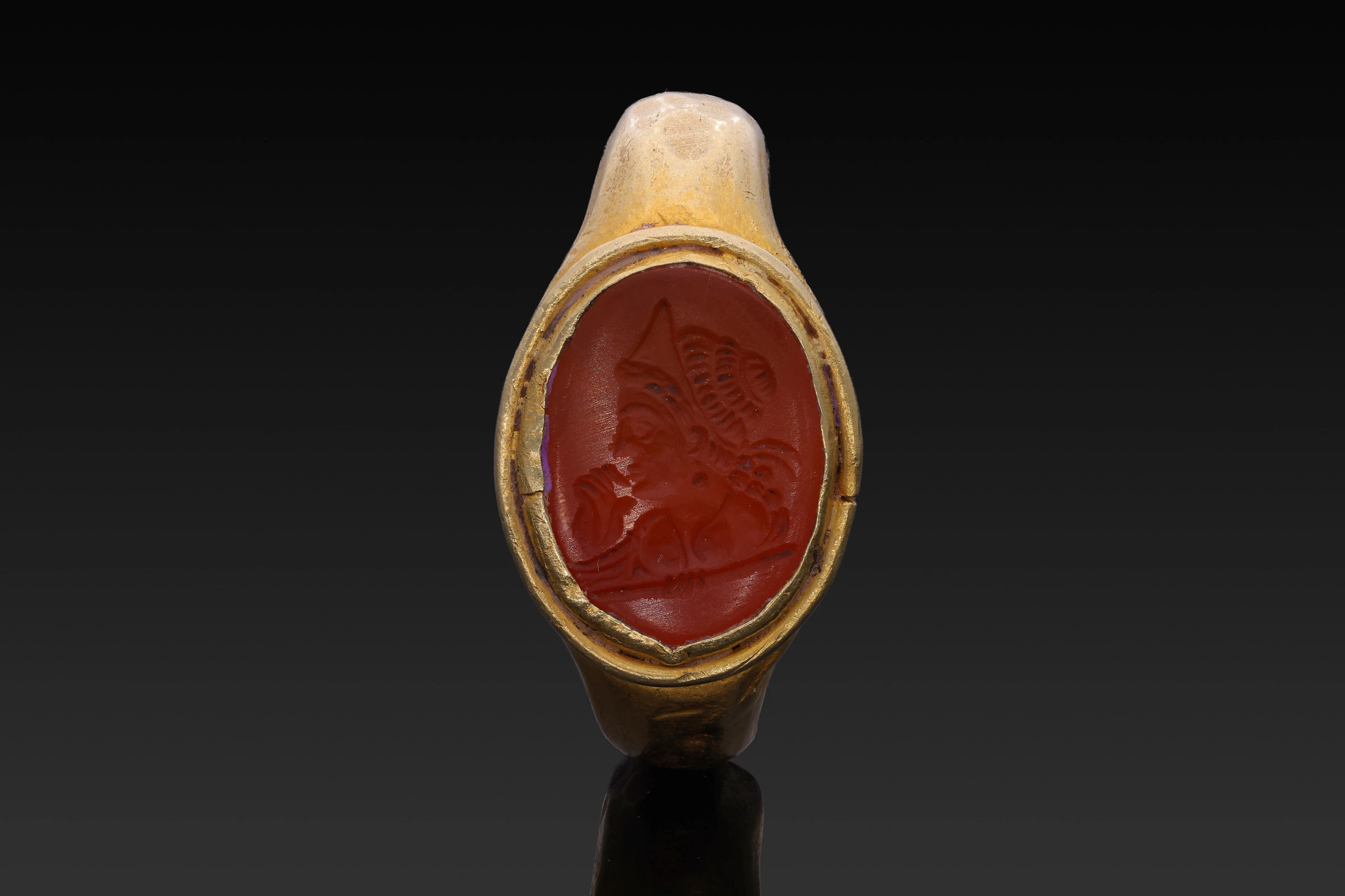 HELLENISTIC CARNELIAN INTAGLIO OF A LADY OF FASHION IN GOLD RING
