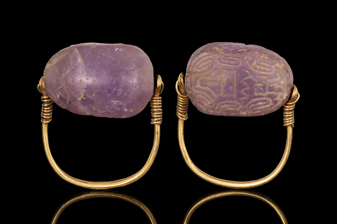 EGYPTIAN GOLD SWIVEL RING WITH AMETHYST SCARAB ENGRAVED WITH SPIRAL MOTIFS