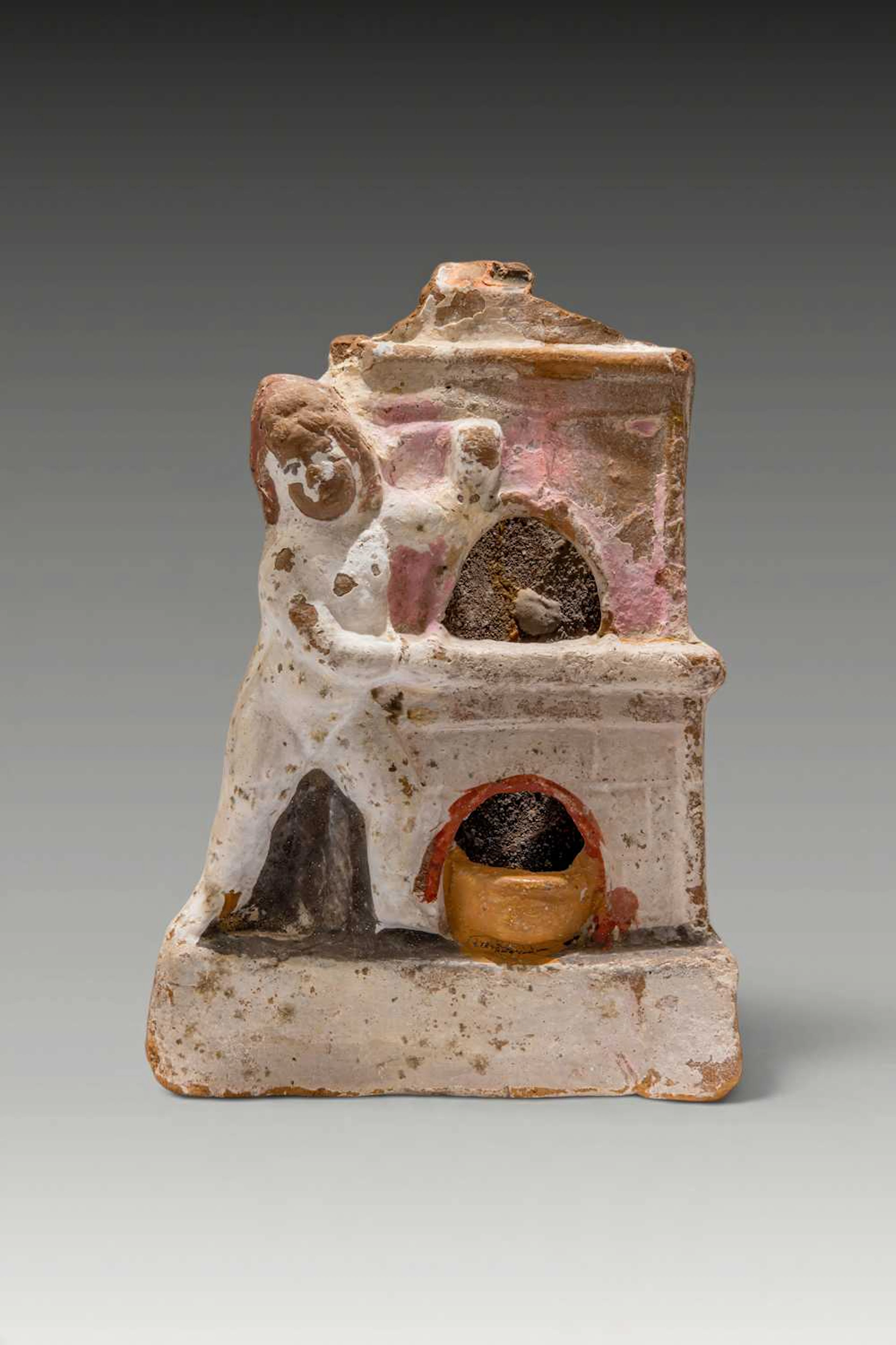 RARE ROMANO-EGYPTIAN PAINTED TERRACOTTA EROS BESIDE AN OVEN