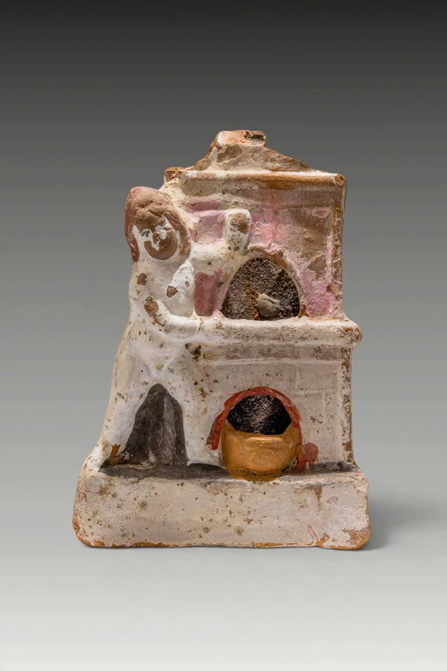 RARE ROMANO-EGYPTIAN PAINTED TERRACOTTA EROS BESIDE AN OVEN
