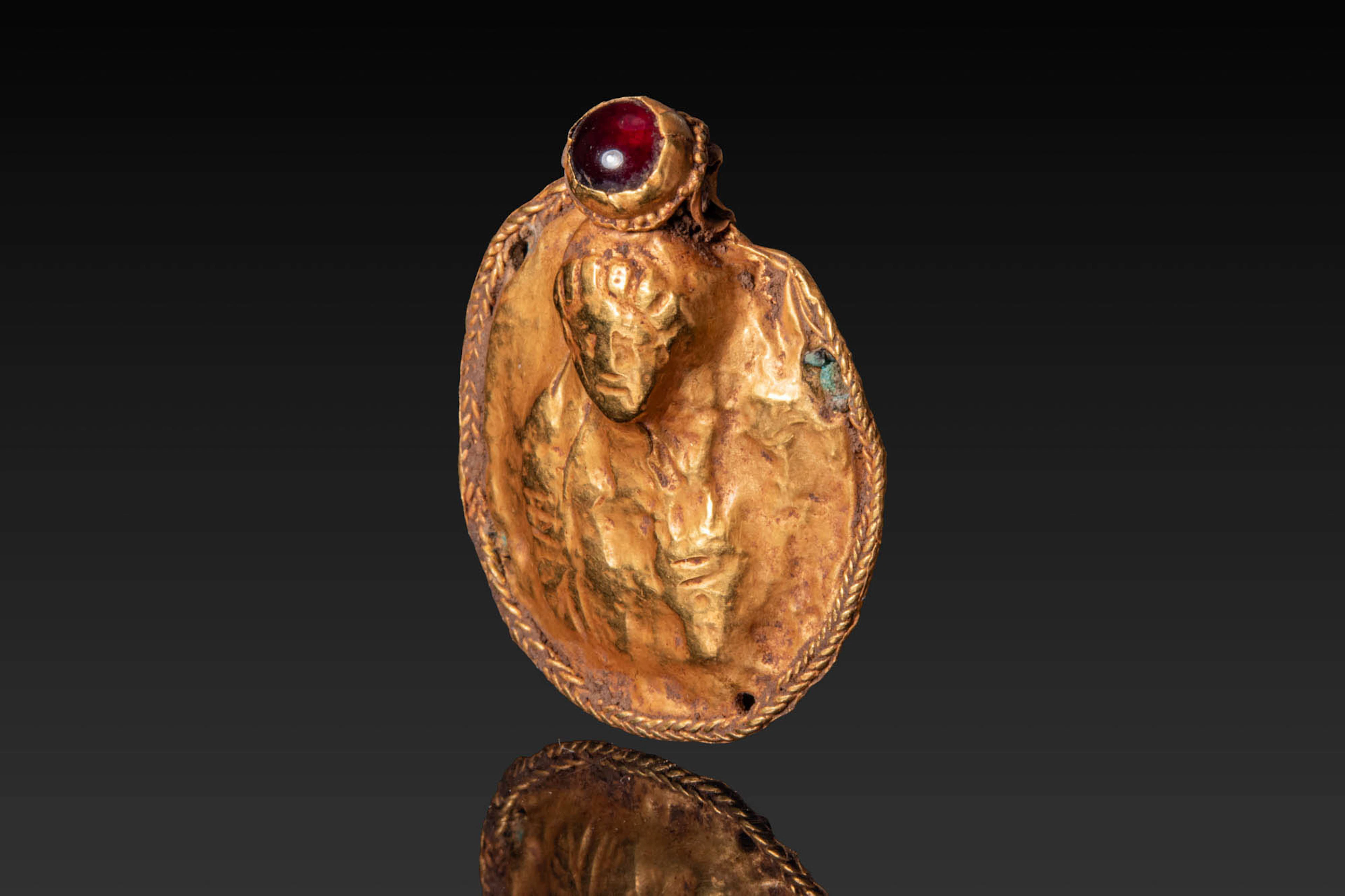BYZANTINE HIGH KARAT GOLD APPLIQUE WITH RED CABOCHON DEPICTING SAINT