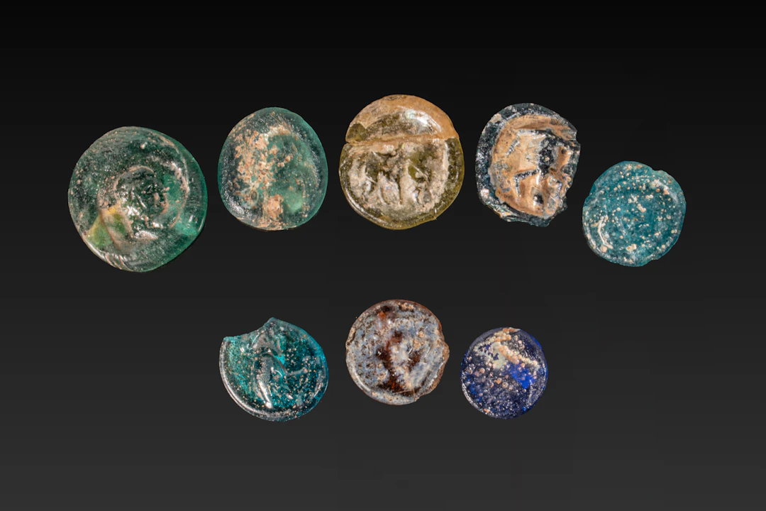 COLLECTION OF ROMAN GLASS COIN WEIGHTS AND A BEAD
