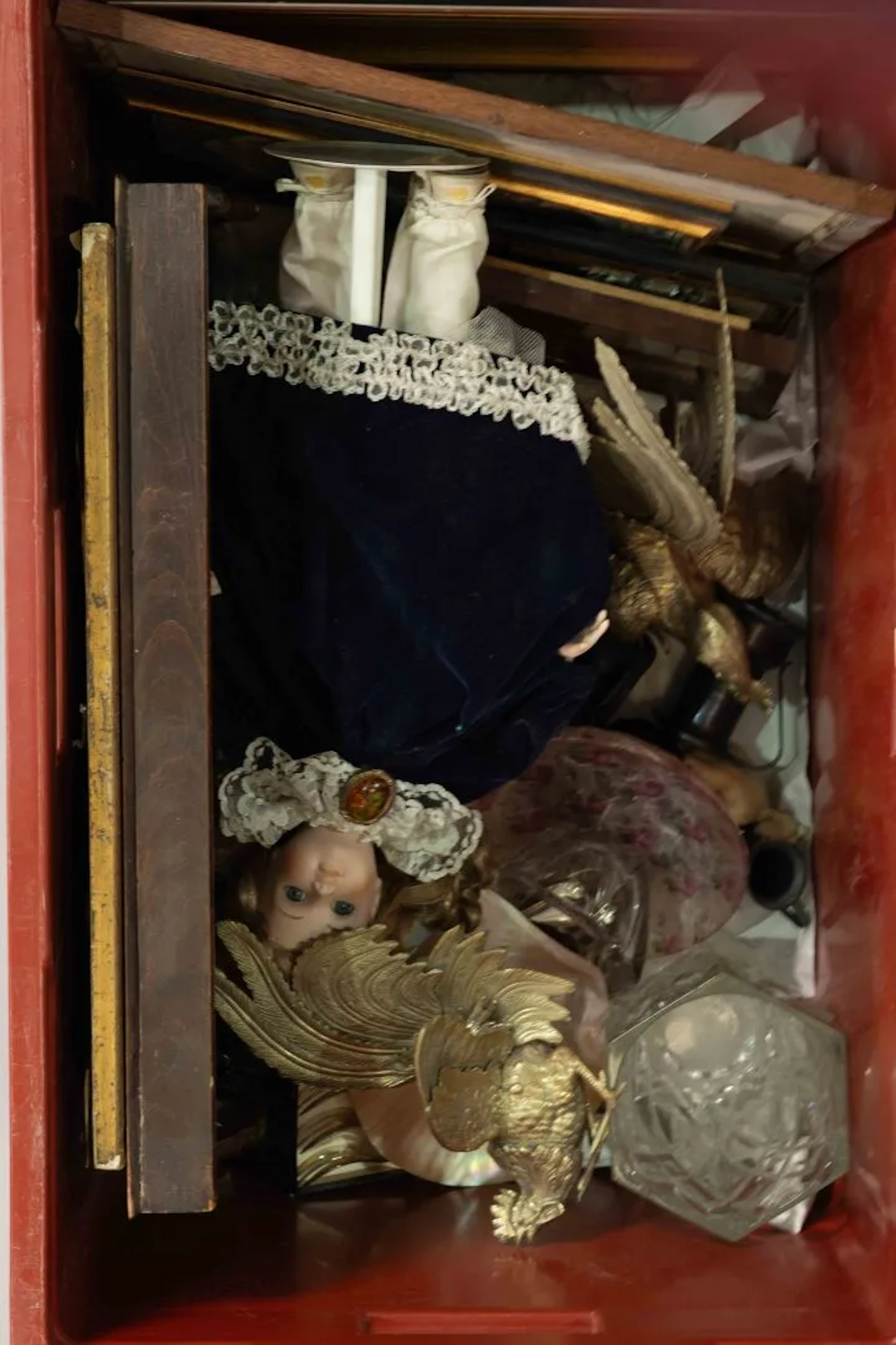 A box of trinkets containing: framed items, a porcelain-head - Lot 201