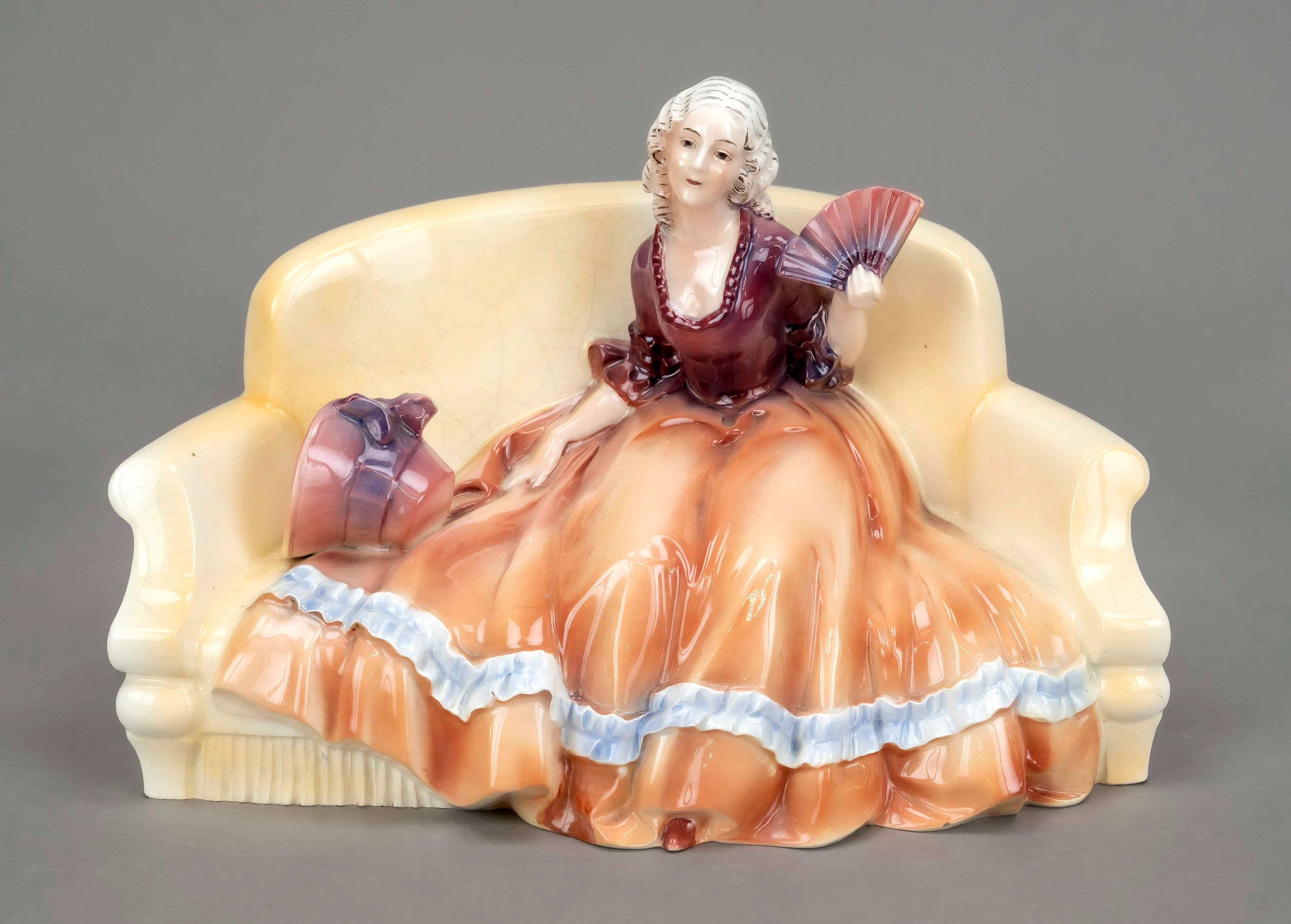 Dame mit Fächer auf Sofa sitzend