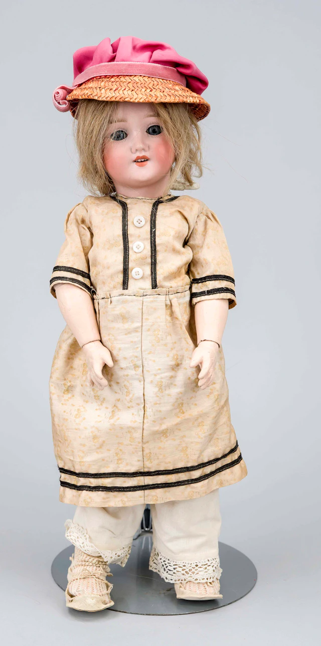 Puppe mit Porzellankopf, um 1900.