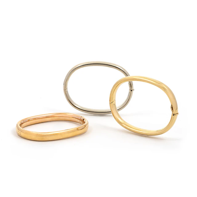 CARLO WEINGRILL, tre bracciali a manetta, anni '50. Oro giallo, bianco