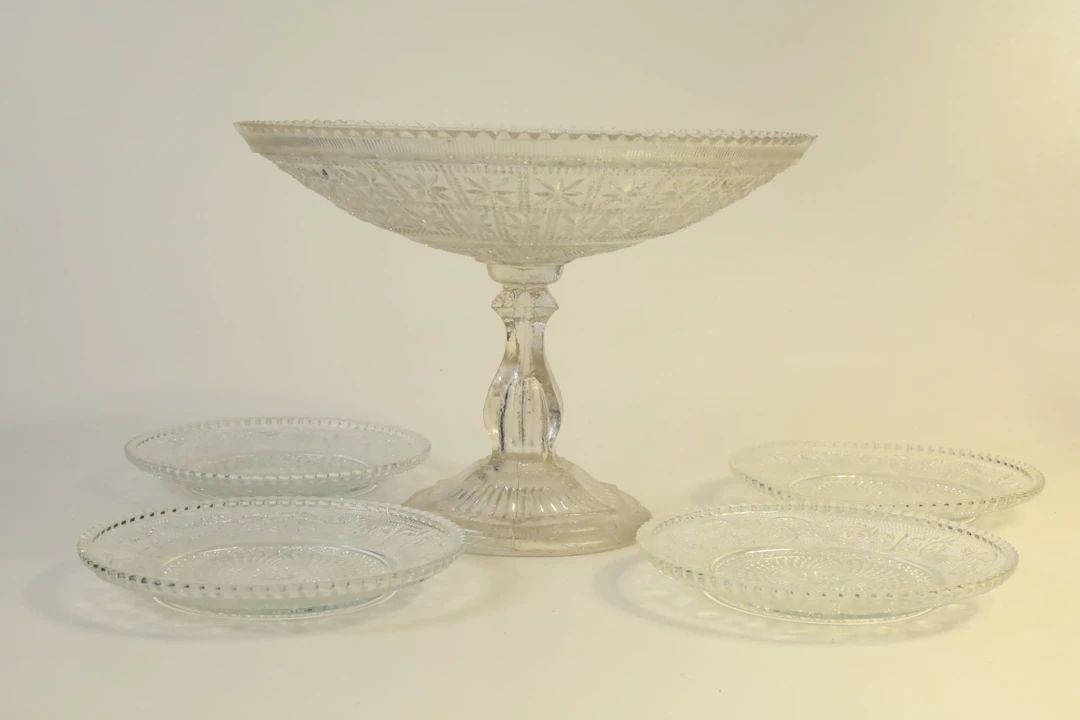 SKÅL PÅ FOT SAMT ASSIETTER, 5 delar, pressglas, 1900-talets första hälft.