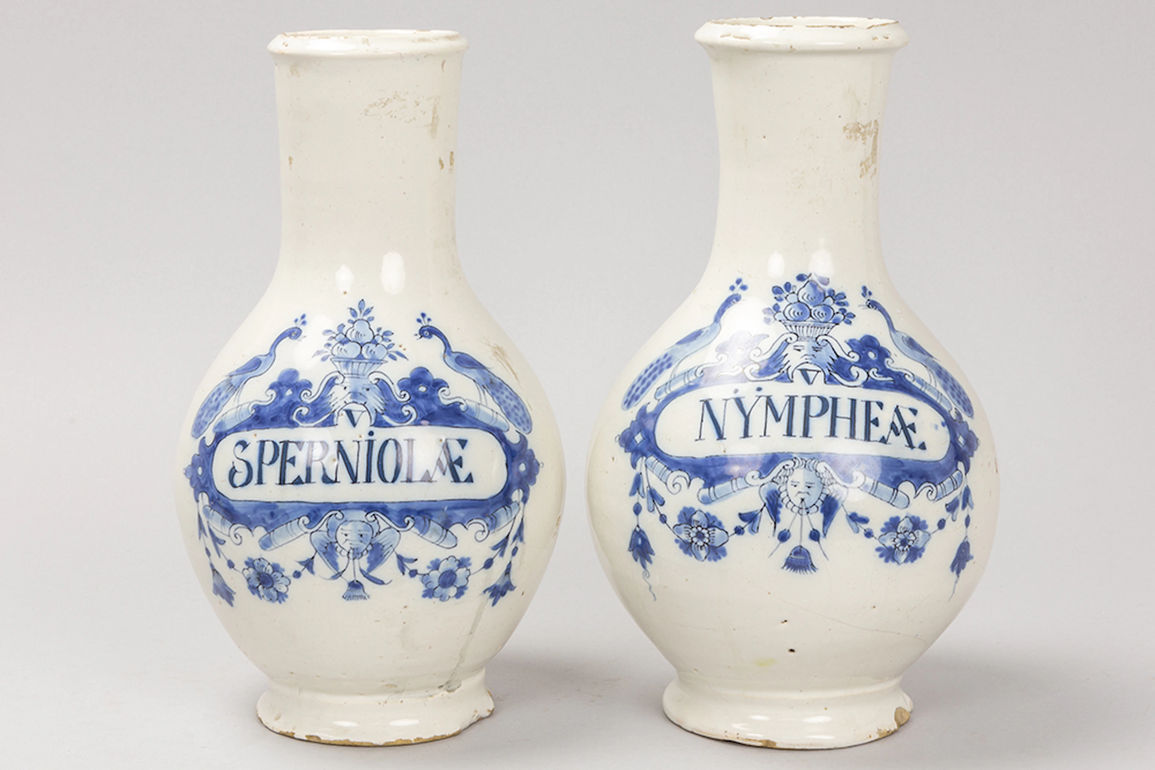 Twee achttiende eeuwse apothekersflessen in faience van Delft met