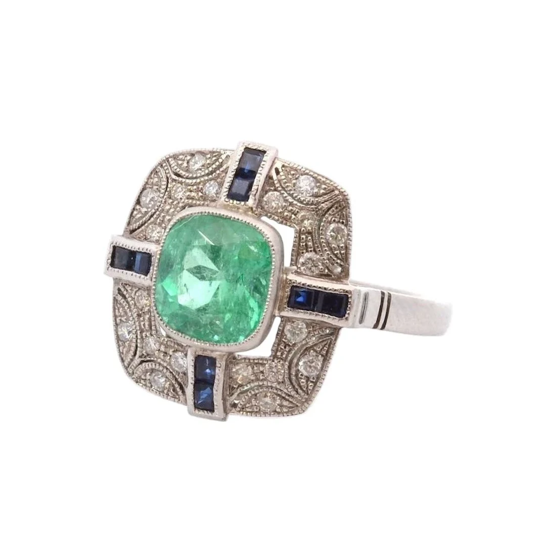Entourage ring in platinum, emerald, diamonds, and sapphires