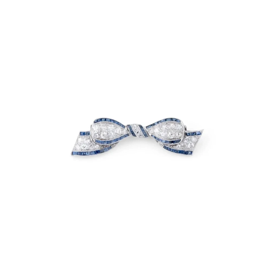 Art Deco platinum bow brooch with diamond and calibrated sapphires