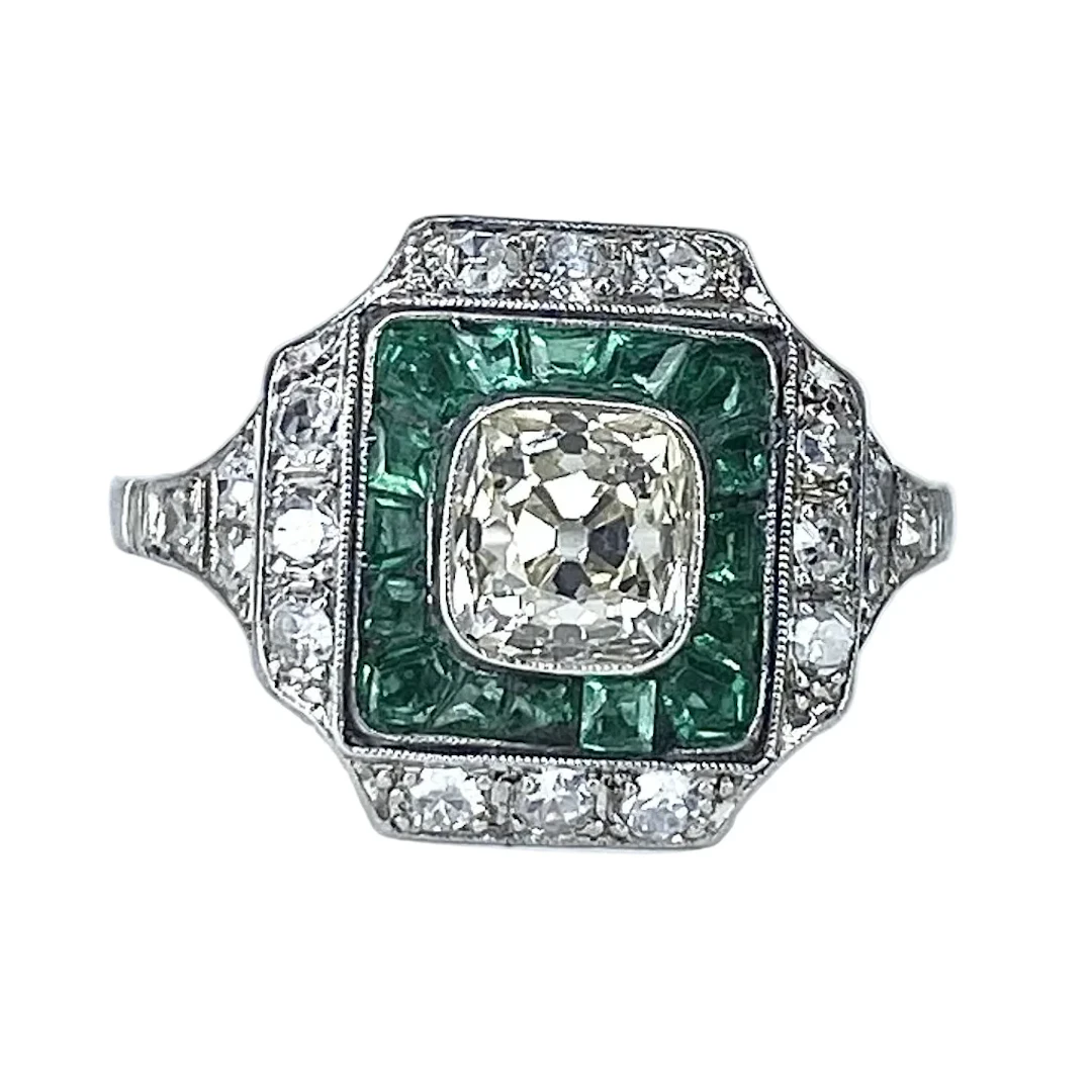 Platinum, emerald and diamond surround ring