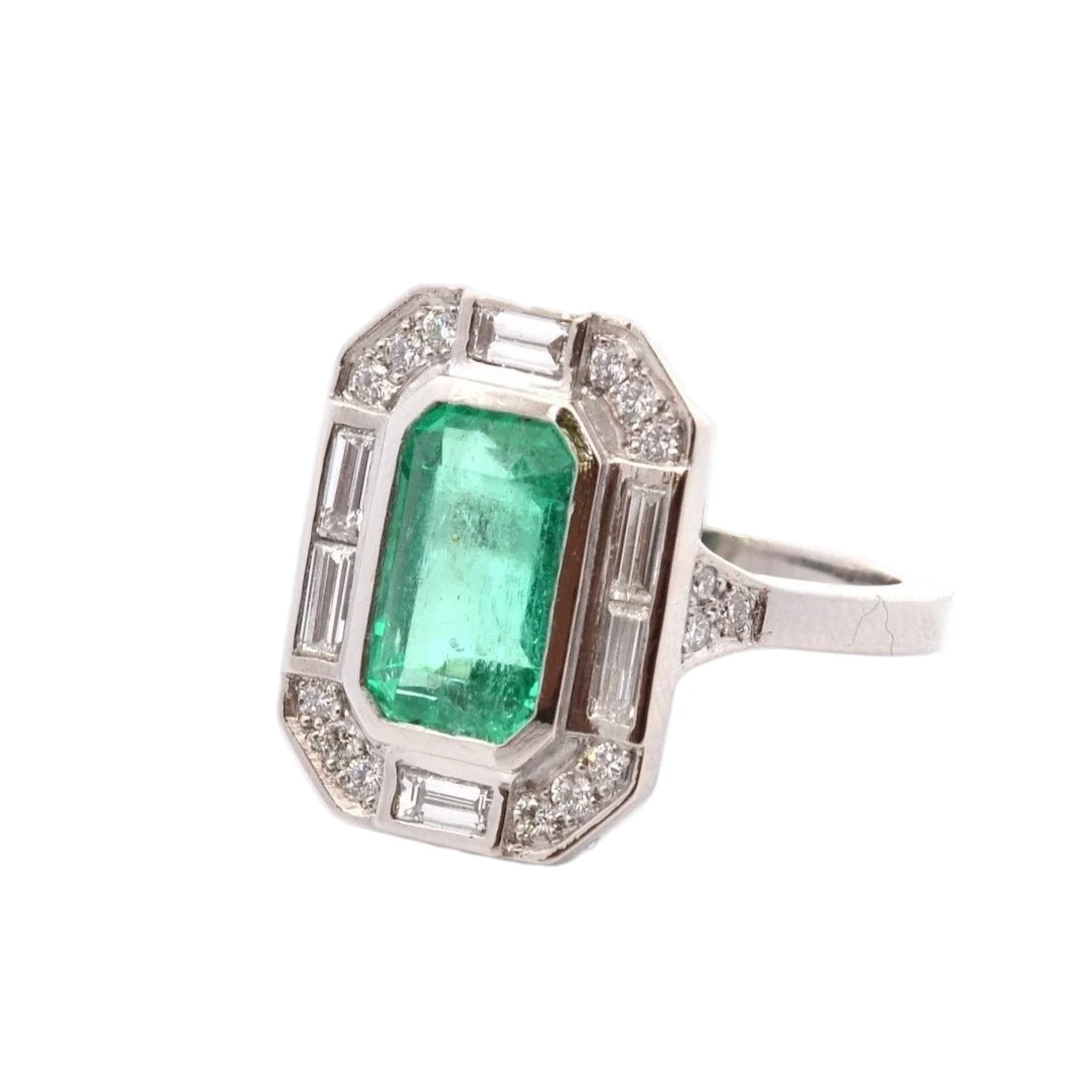 Platinum, emerald, and diamond surround ring