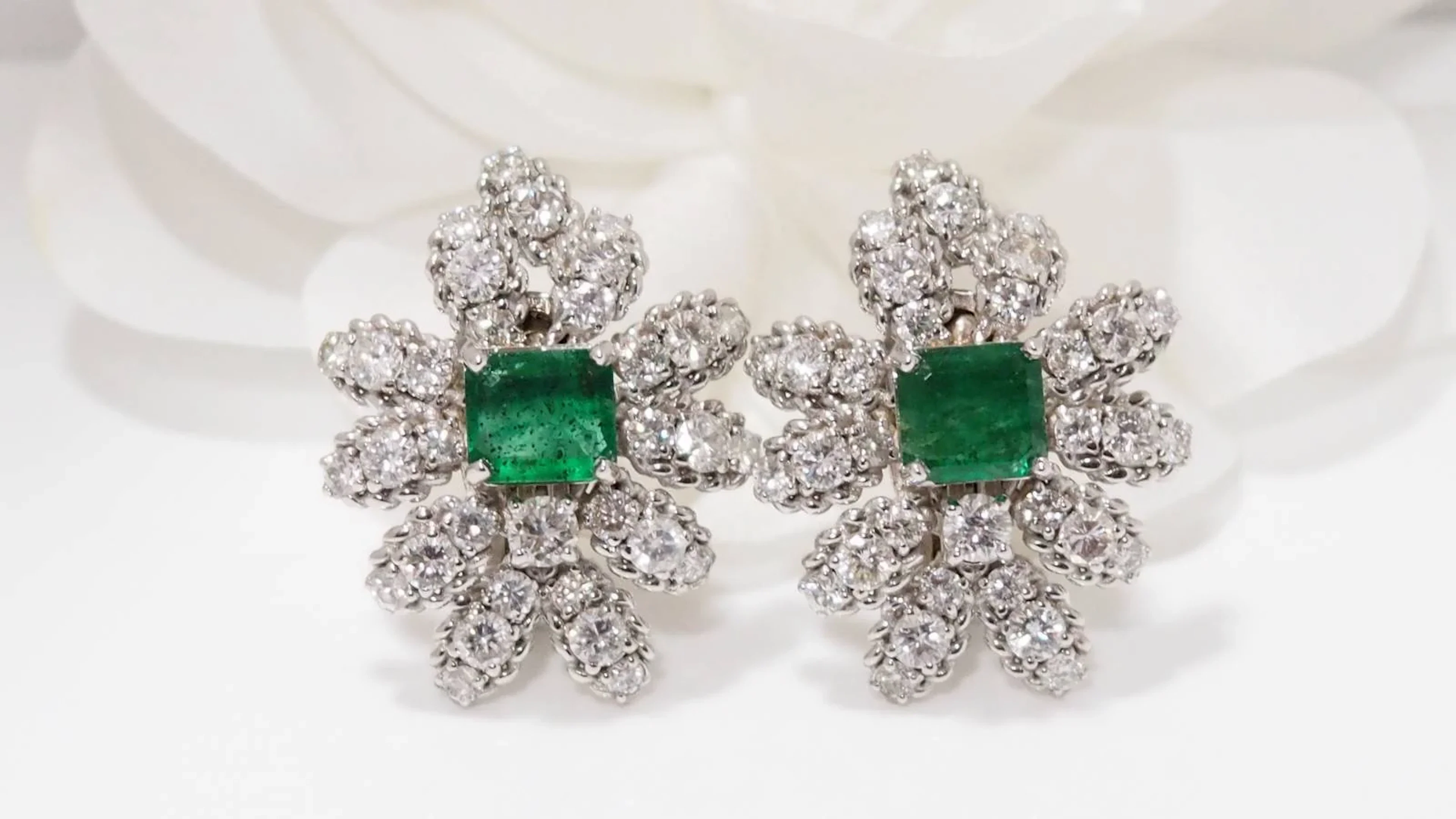 Statement clip-on earrings in white gold with emeralds and diamonds