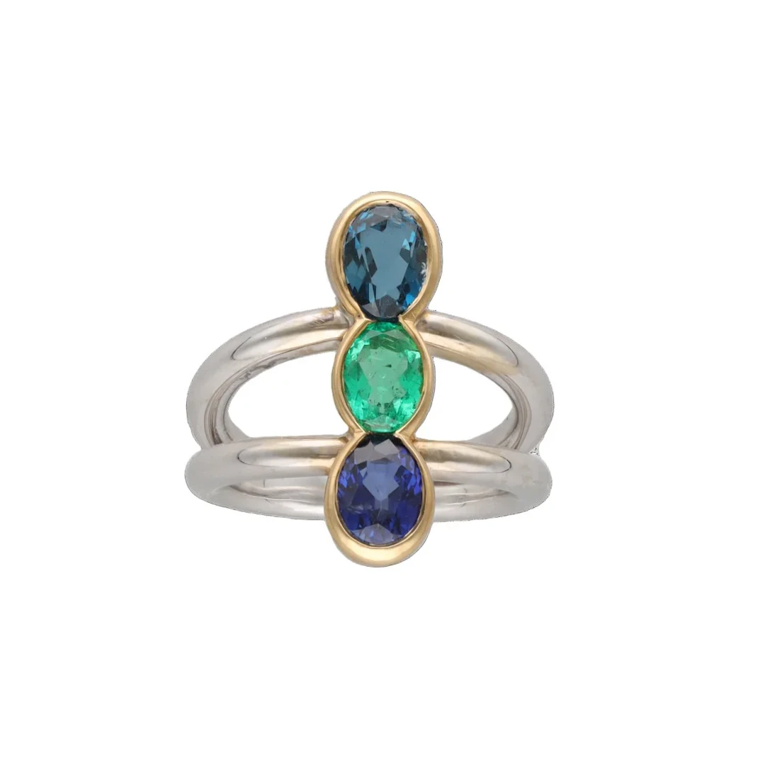 Trilogy ring in white gold, yellow gold, emerald, sapphire and topaz
