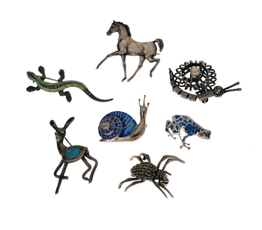 Group of seven silver and other animal brooches