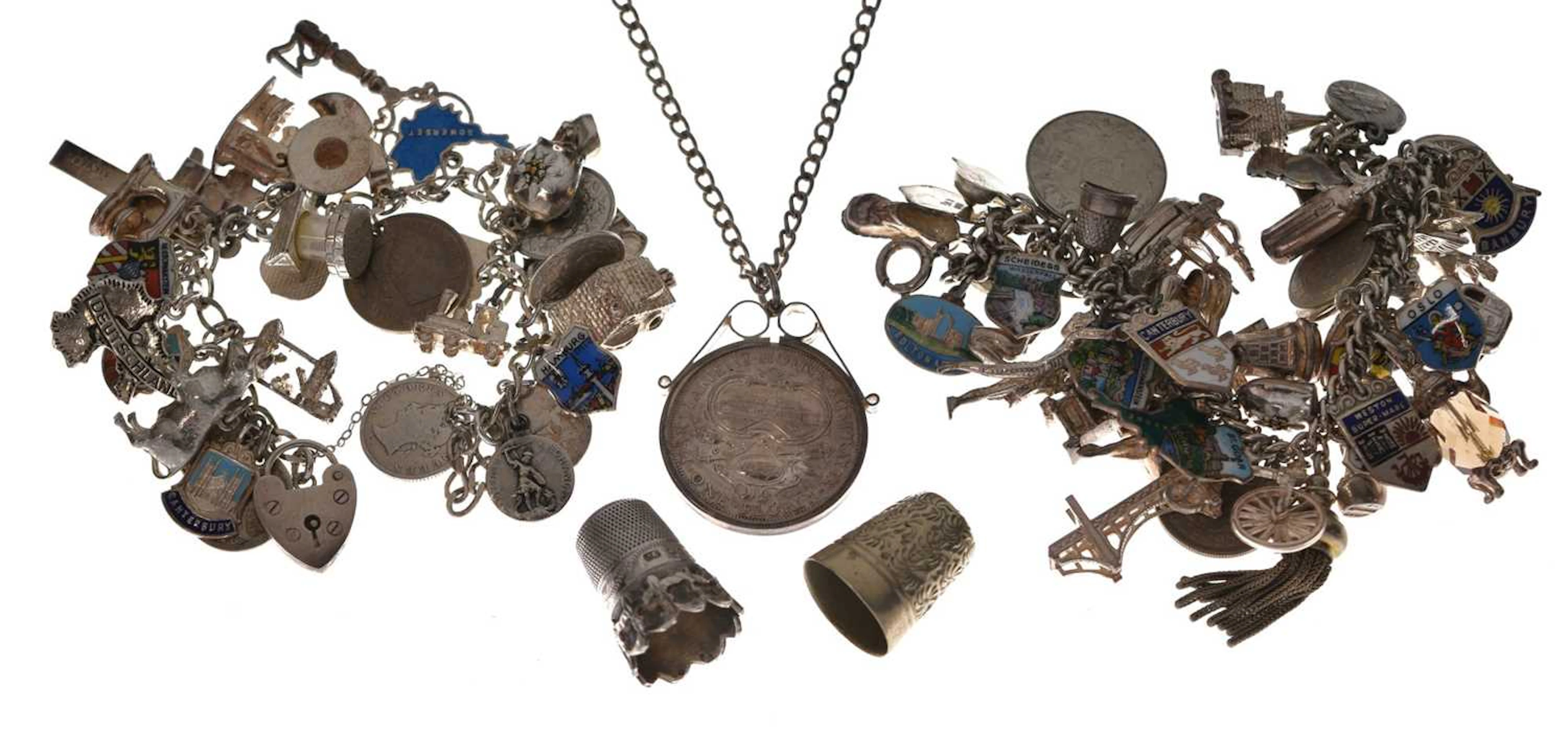 Two silver charm bracelets, two thimbles, and a mounted Australian