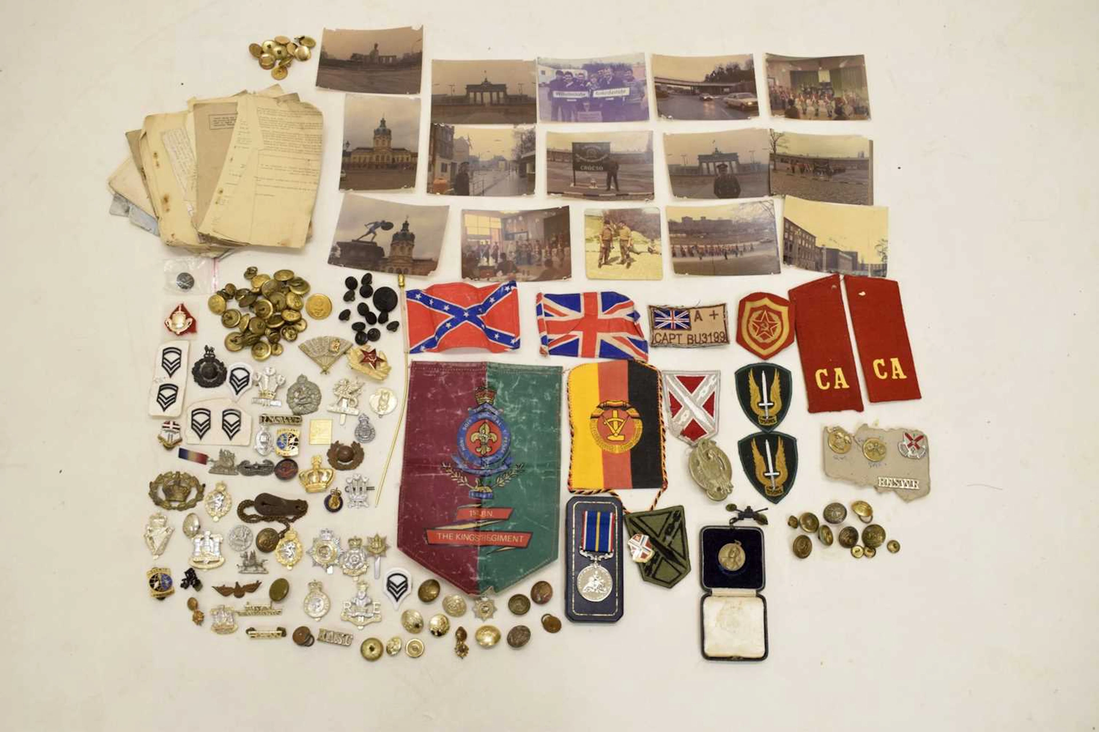 Collection of military buttons, uniform patches and cap badges