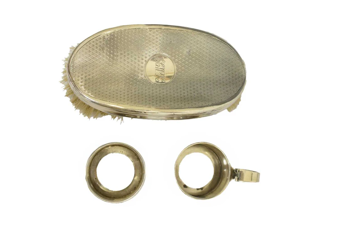 Two silver cruet mounts and a silver backed brush