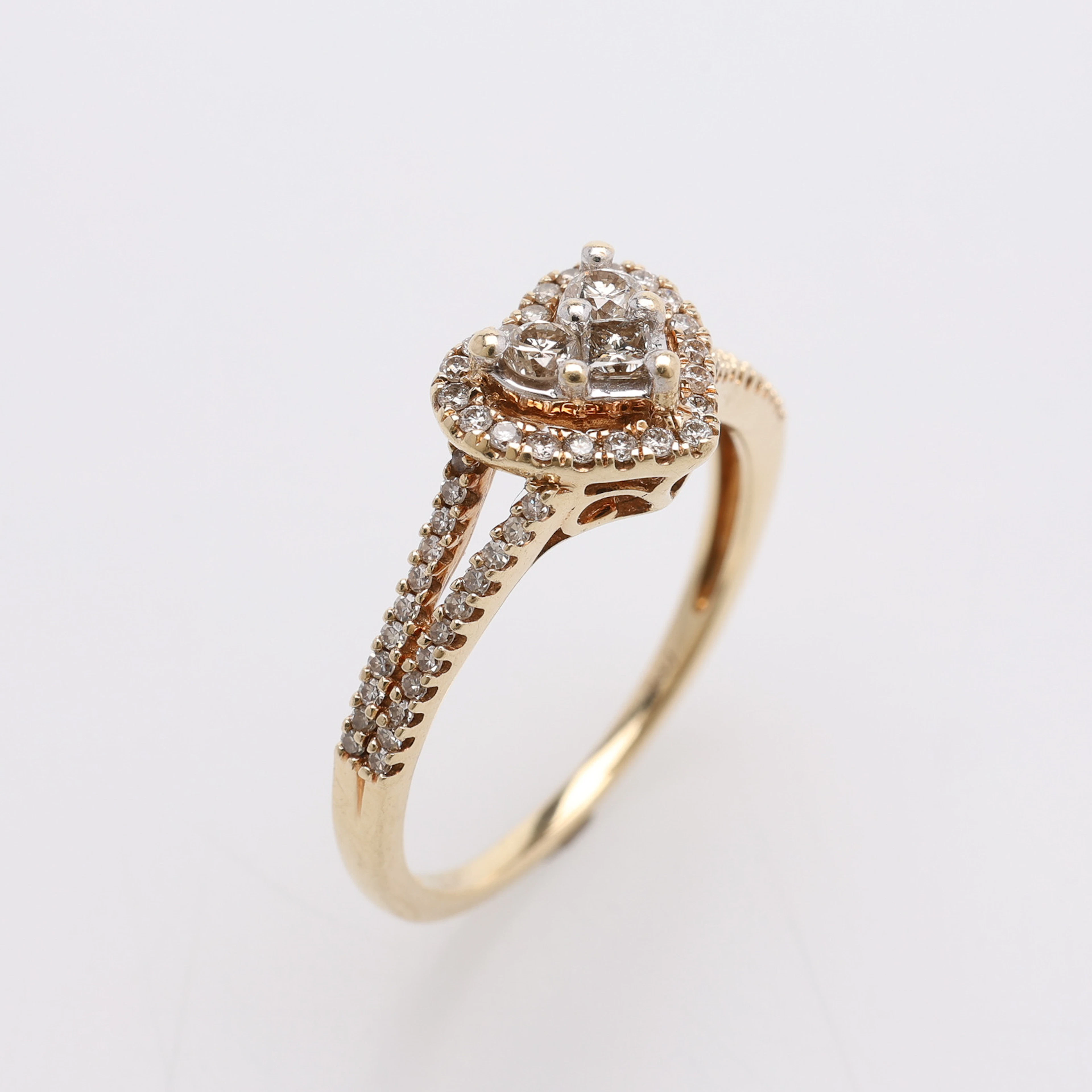 RING, 10K GULD, MED HJÄRTFORMAD FATTNING AV STENAR TOTALT CA 0,55 CT.