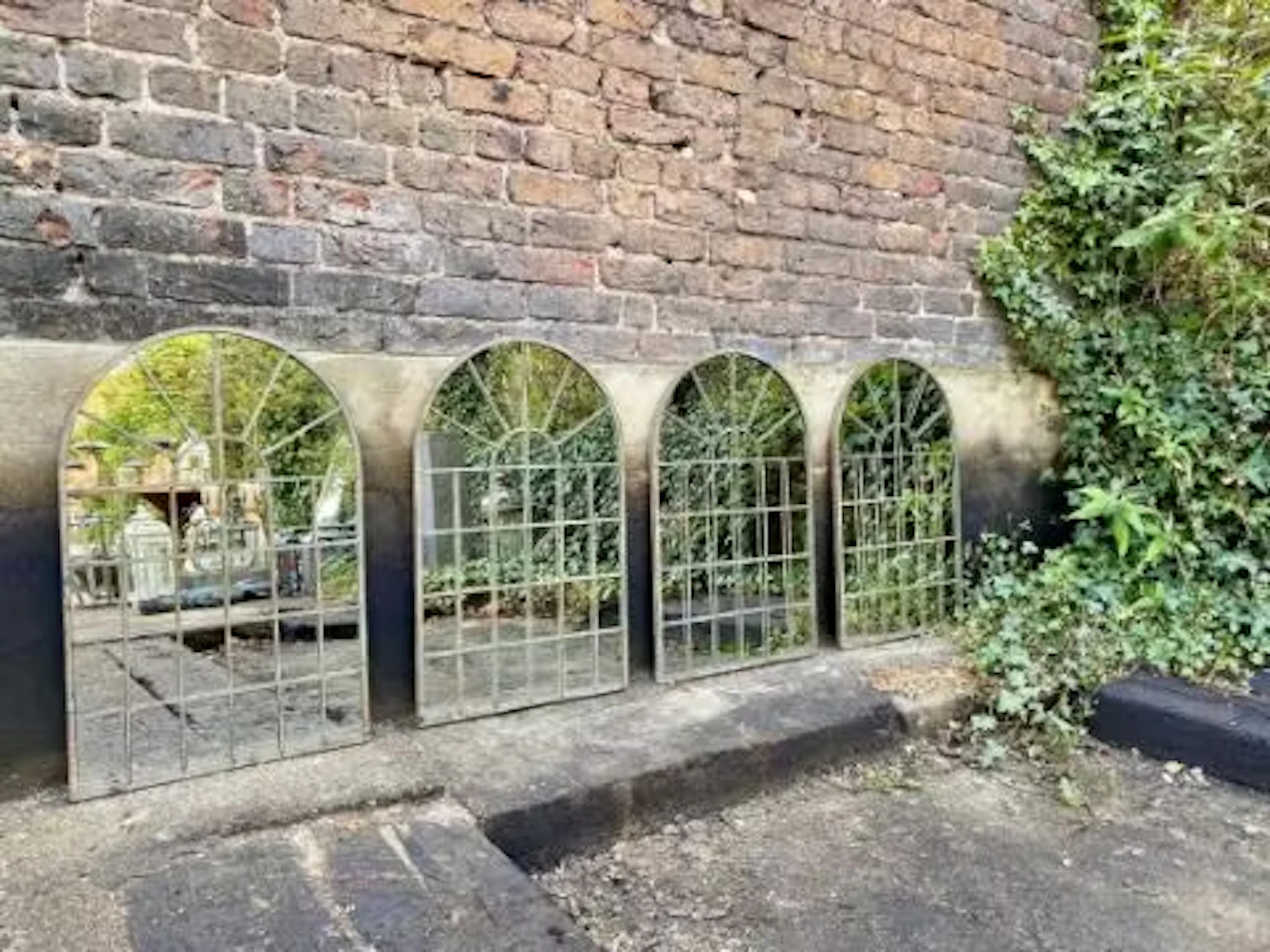 A set of four Regency style garden mirrors, architecturally styled