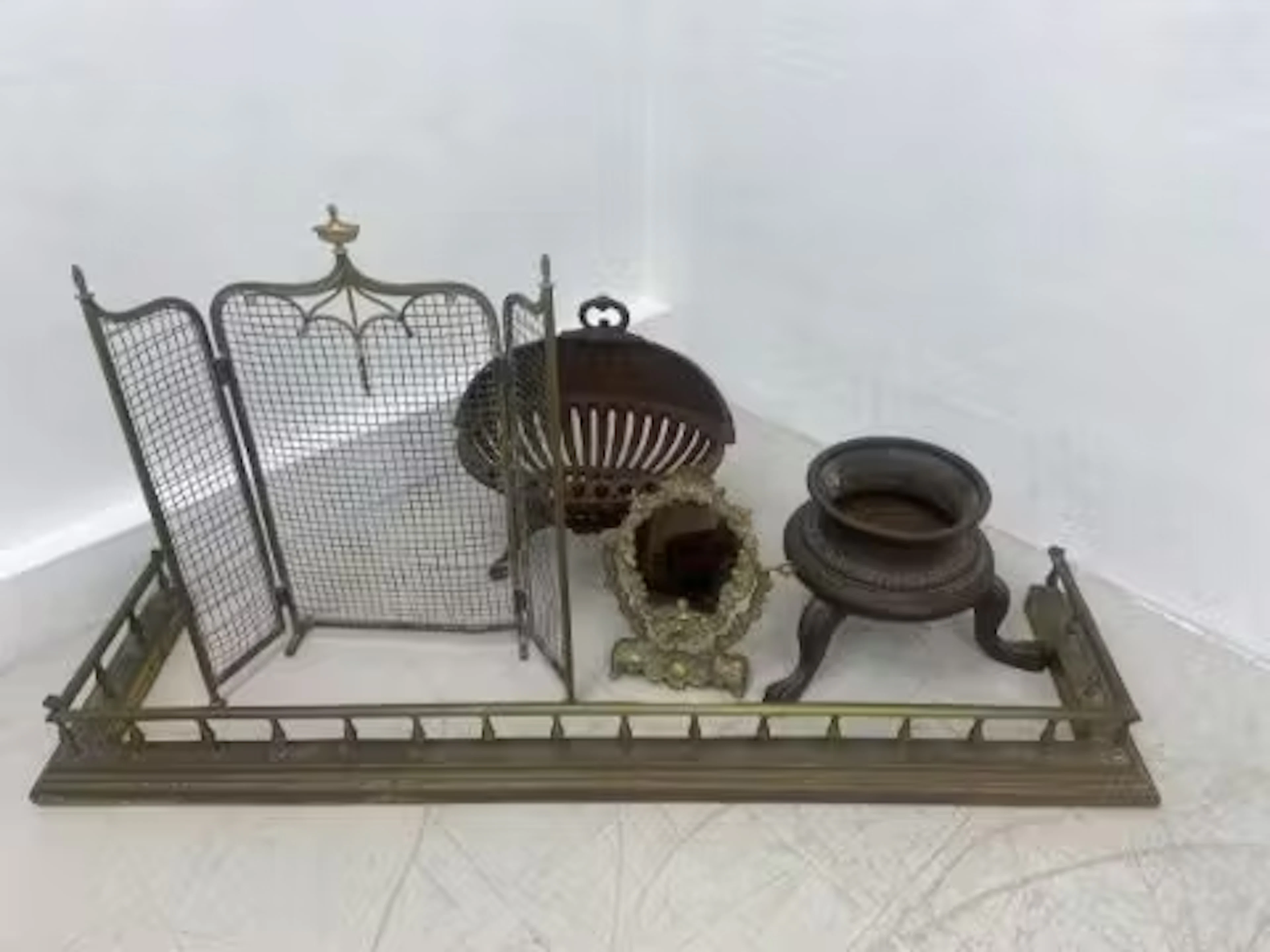 A mixed lot to include a brass fire kerb, cast iron footed urn, a