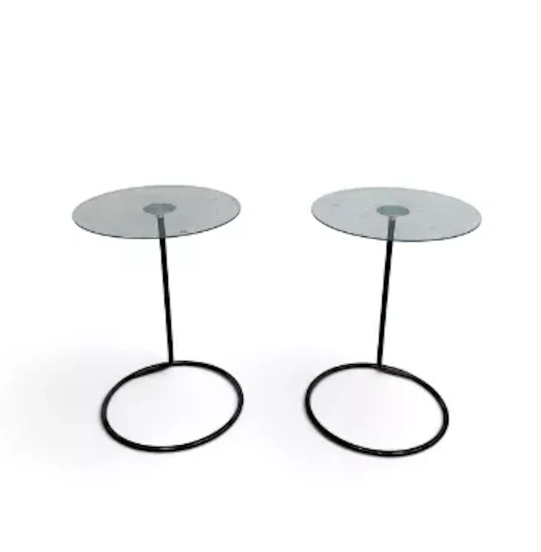 A pair of retro styled Umbra loop tables with plate glass tops on