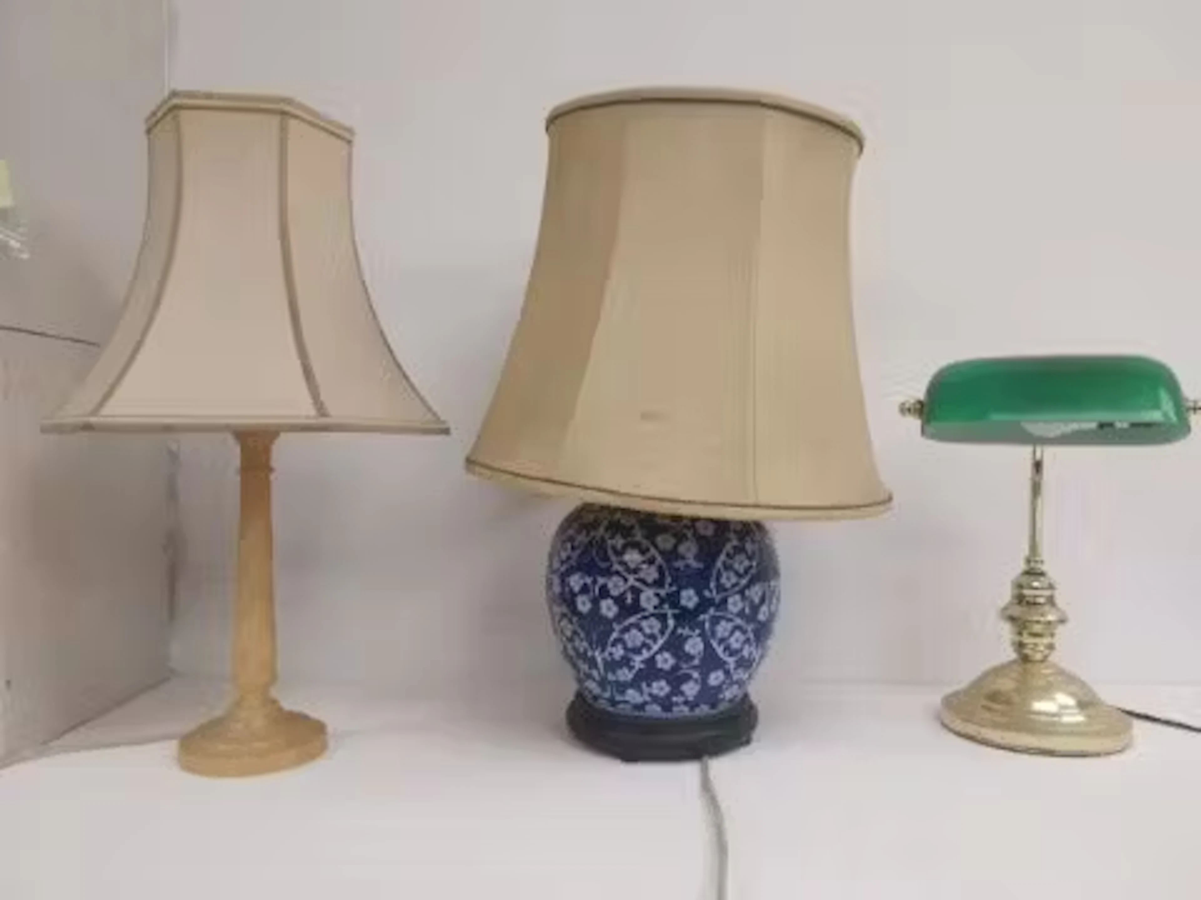A banker's desk lamp with green glass shade along with two table lamps