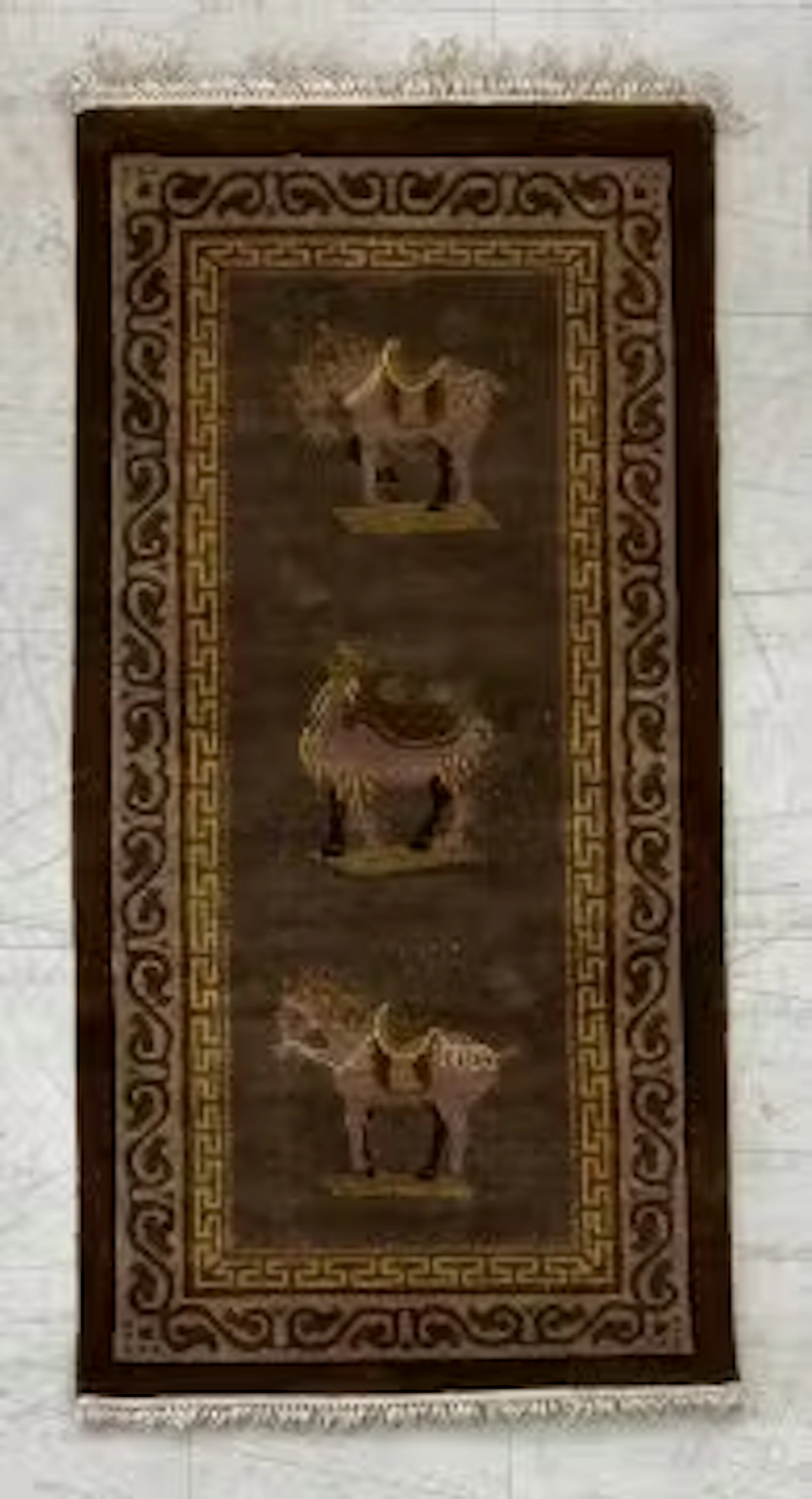 A Chinese silk rug with Tang style figural horse and camel motifs