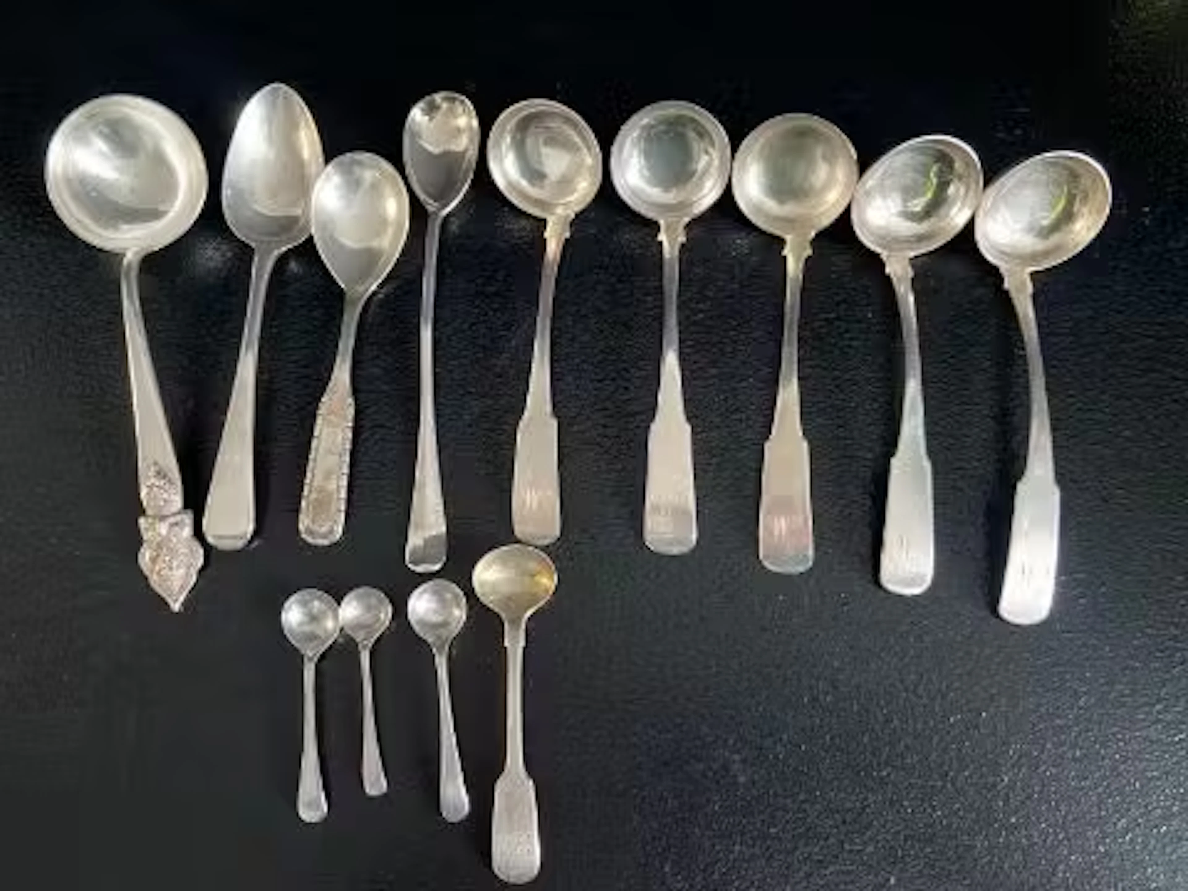 A set of five hallmarked silver sauce ladles along with various spoons