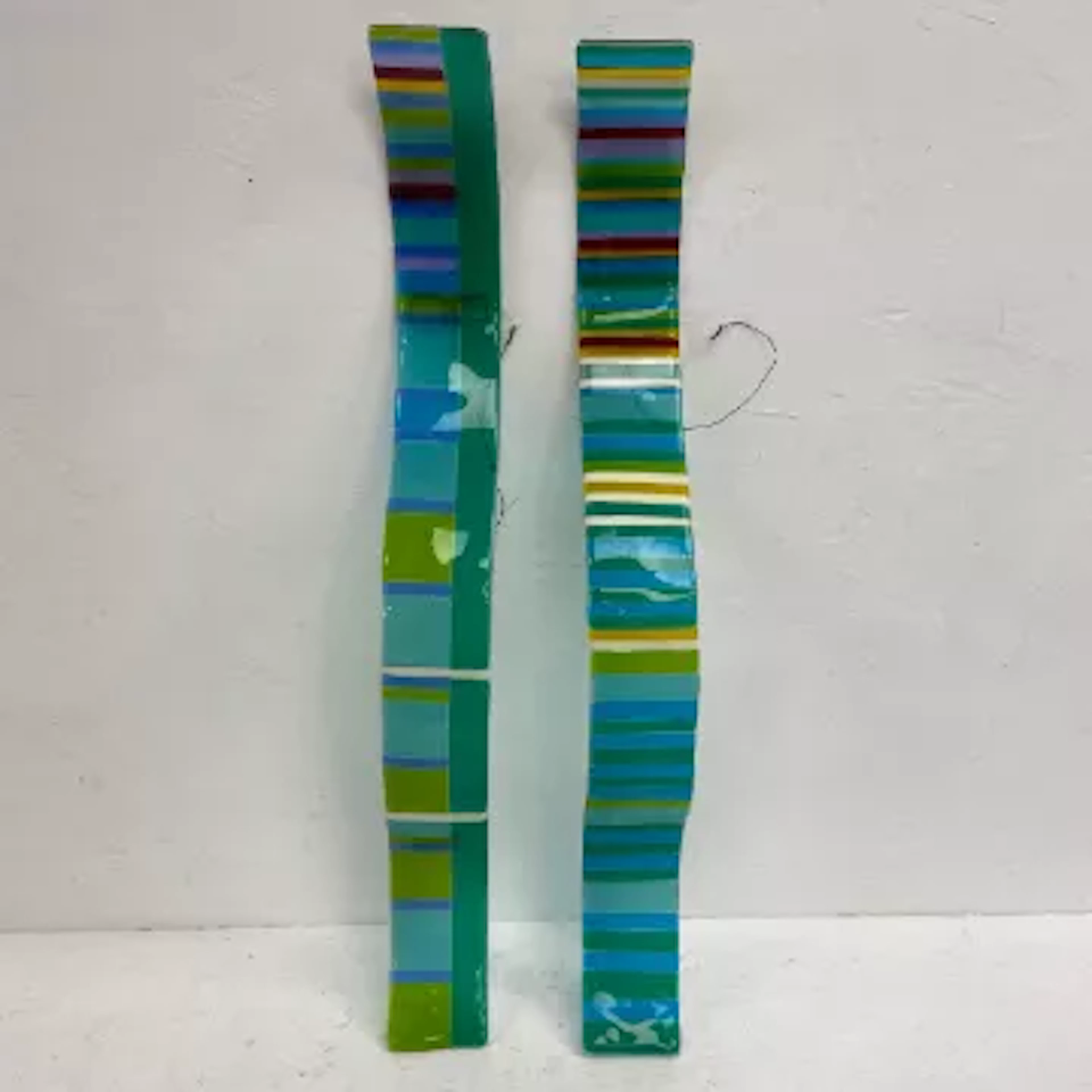 A pair of hand blown coloured art glass applique wall sculptures of