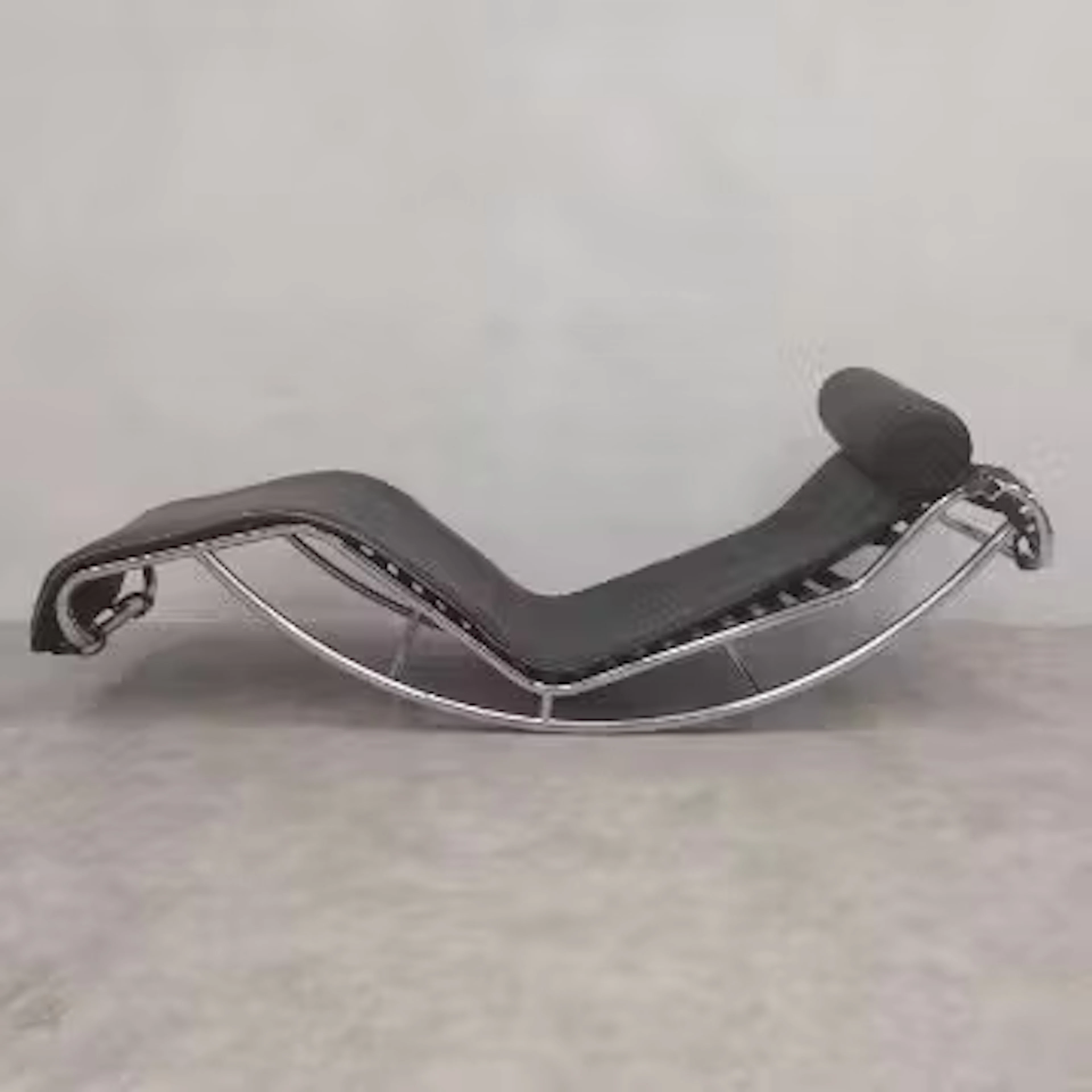A vintage leather upholstered LC4 style chaise longue on a bent tubular