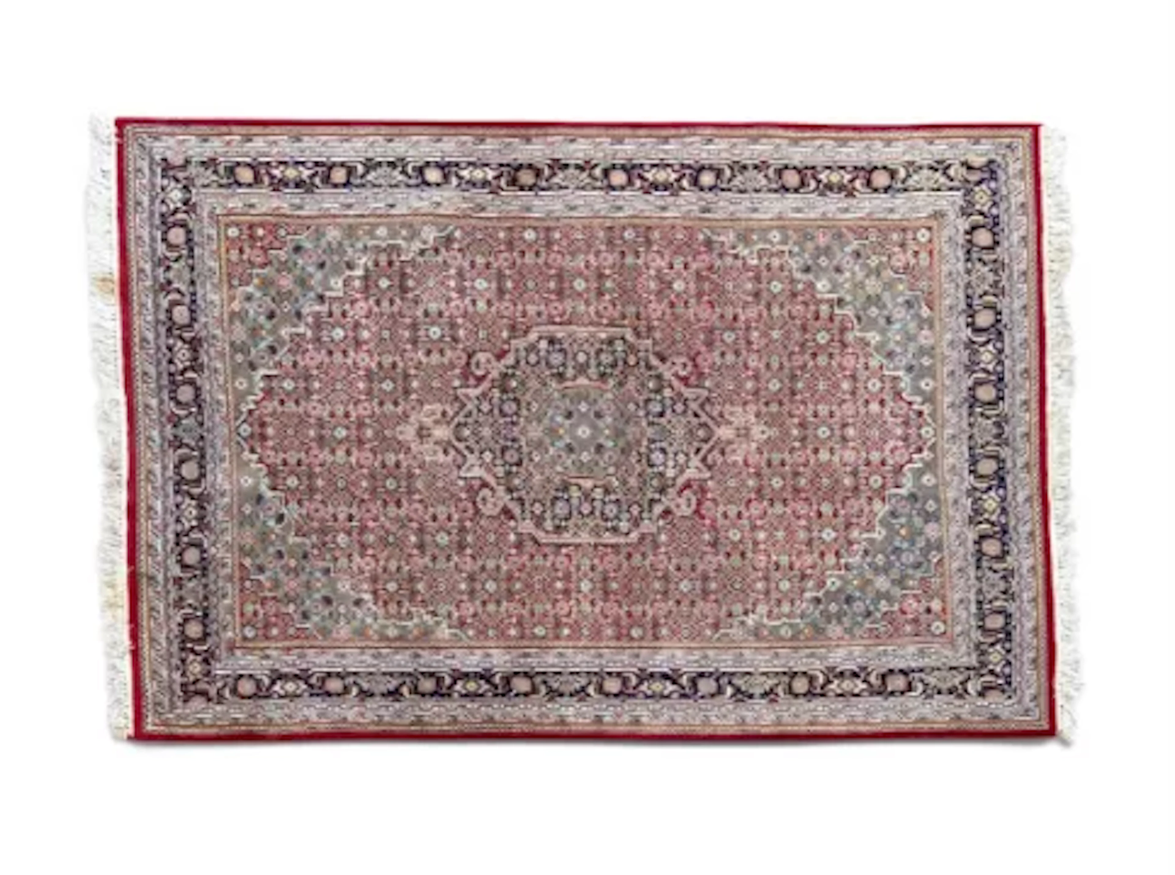 A Kazak carpet with a central lozenge medallion on a burgundy field