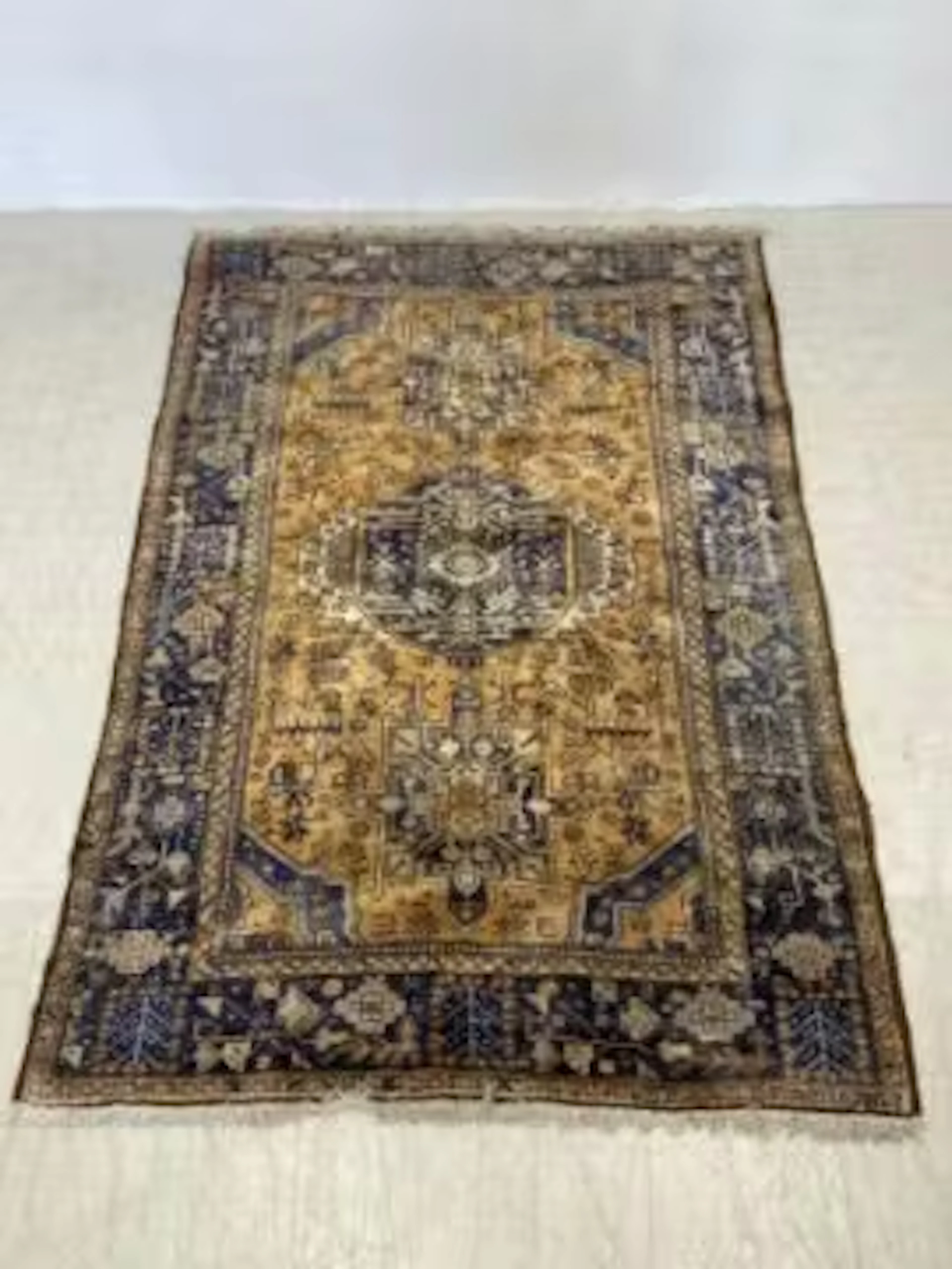 A Shiraz carpet with central stylised hooked medallions on a sand
