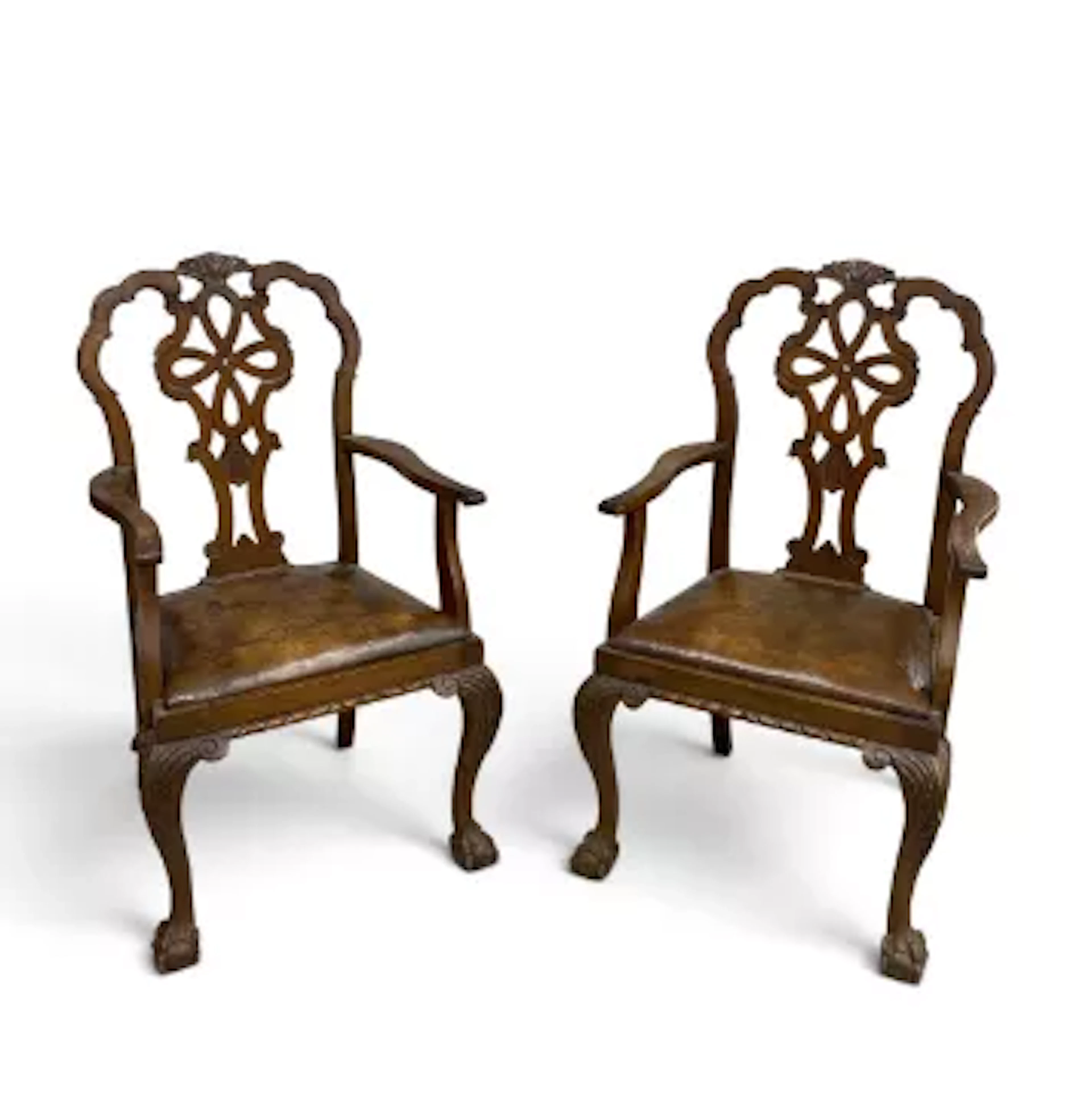 A pair of early Georgian style open armchairs with distressed leather